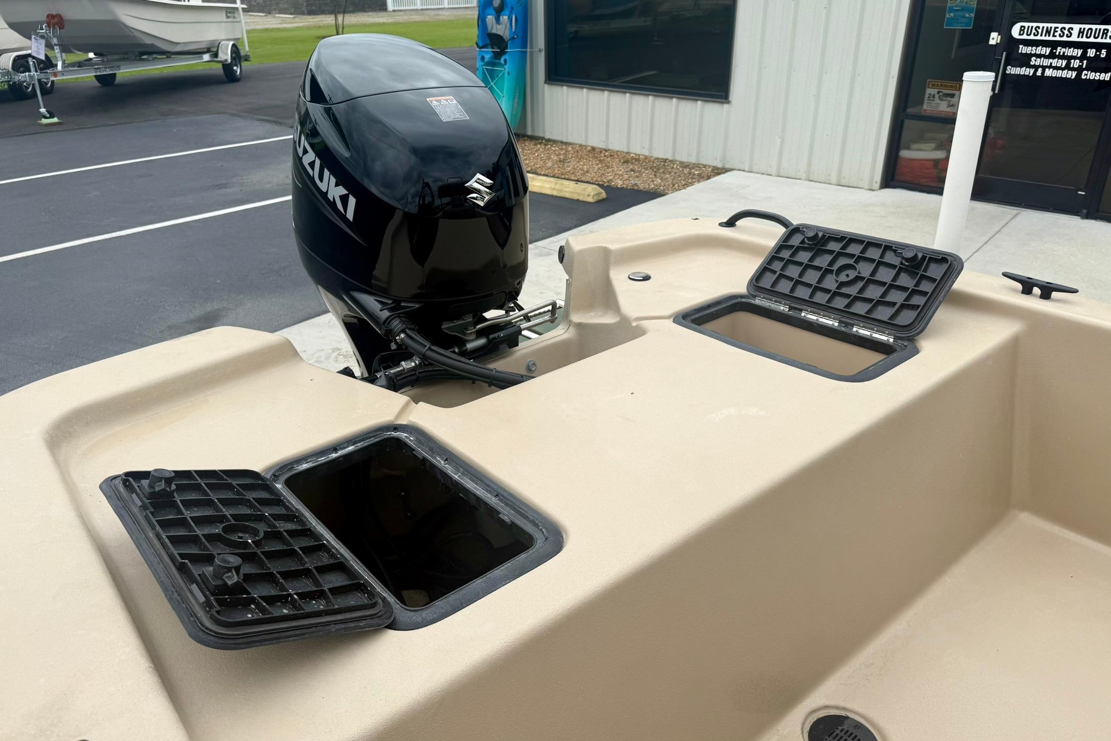 2026 Carolina Skiff E18 JVX CC boat with Suzuki outboard motor and open storage compartments.