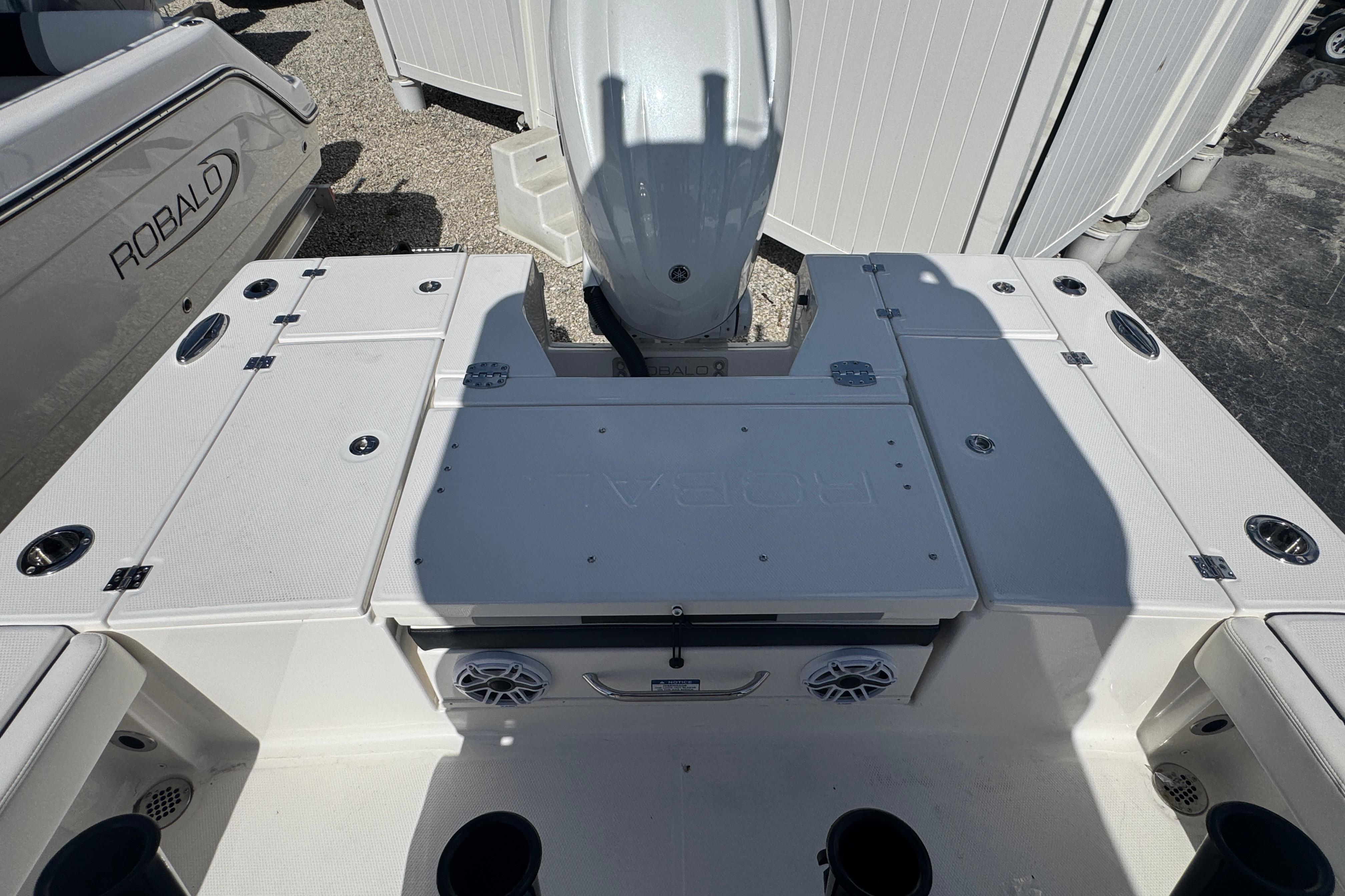 2025 Robalo 246 Cayman SD boat deck with storage compartments and motor.