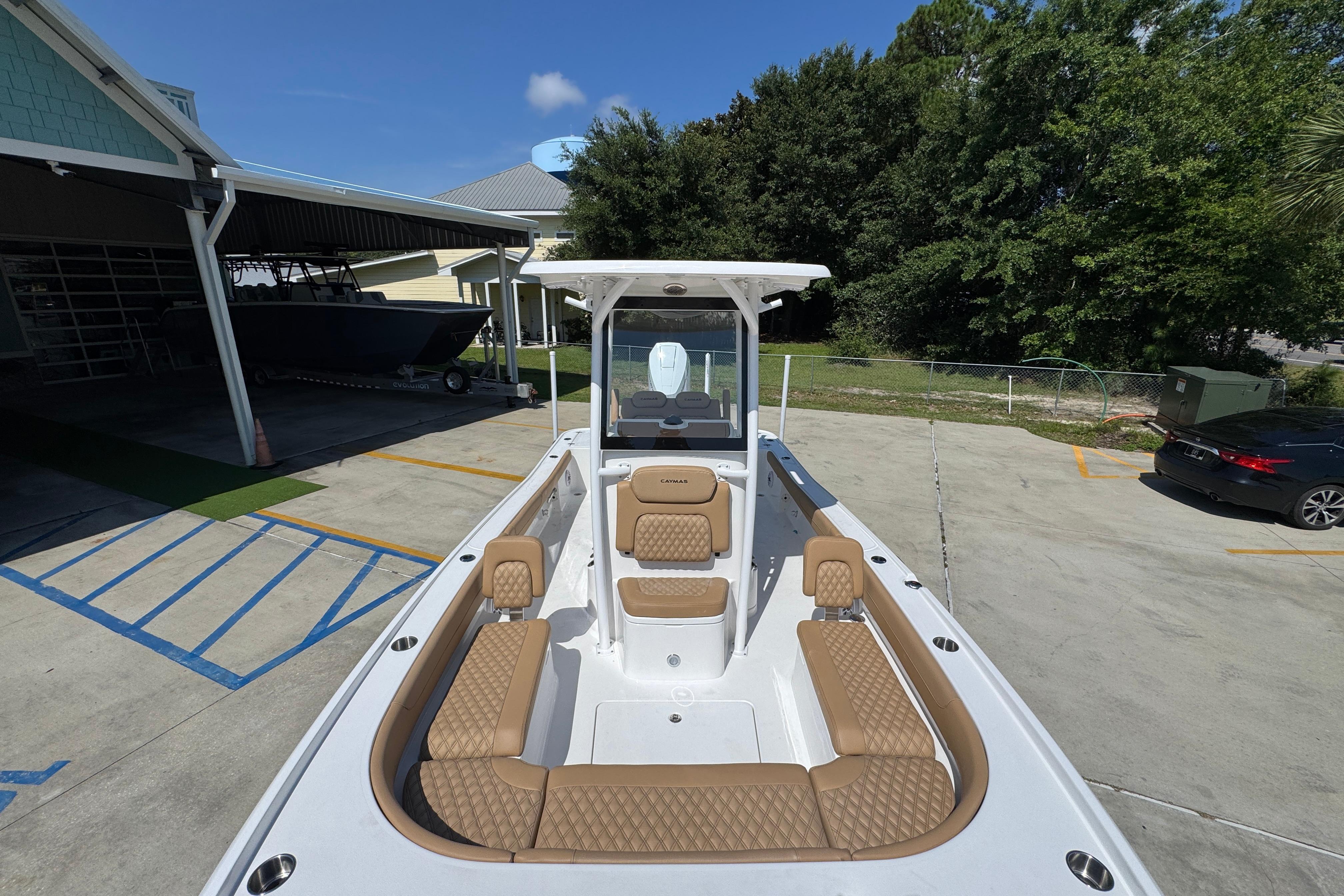 2027 Caymas 26 HB boat with tan seating, parked outdoors on a sunny day.