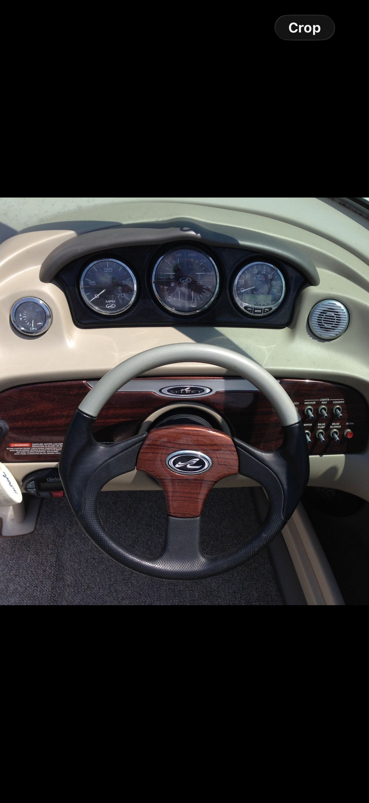 The image shows the dashboard of a 2004 Sea Ray 220 Select boat with wood paneling.
