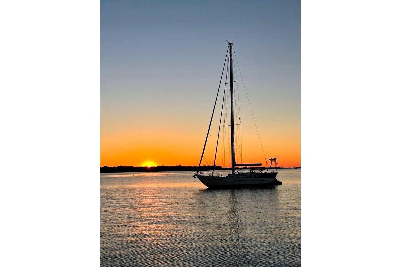 Sailboat silhouetted against a vibrant sunset, Reliance 44 model, 2011.