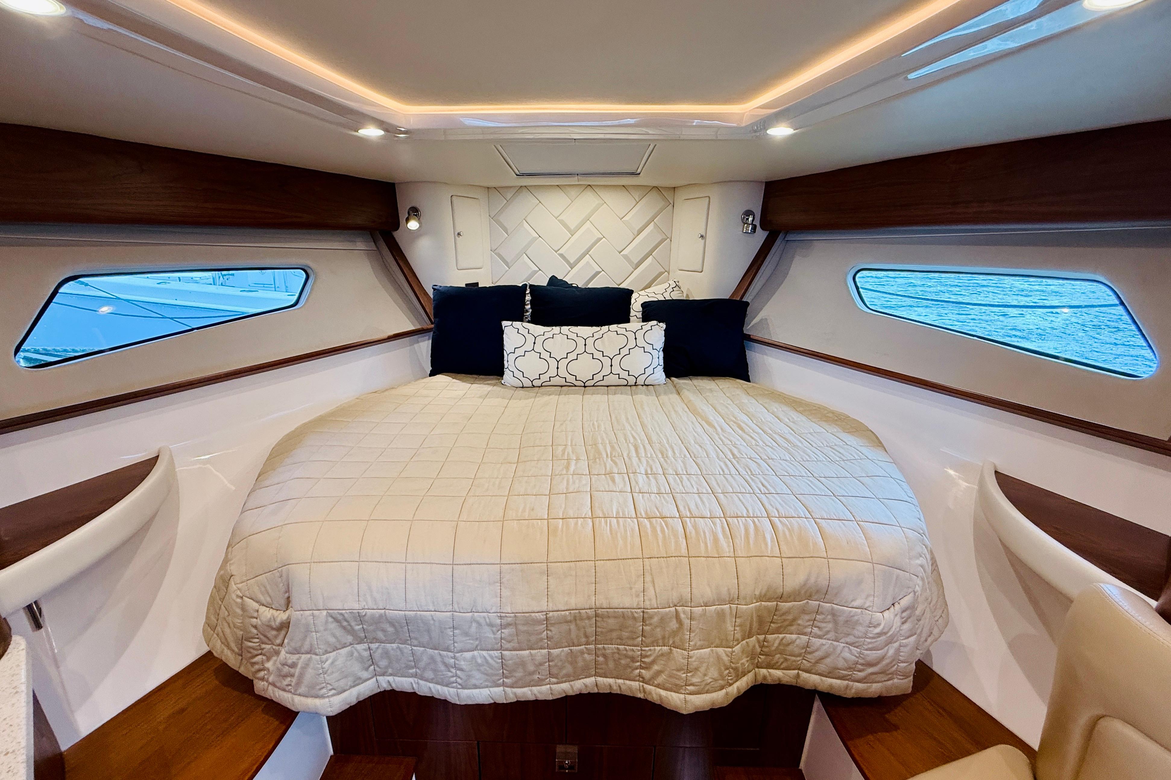 Luxurious cabin interior of 2021 Intrepid 410 Evolution yacht with cozy bedding.