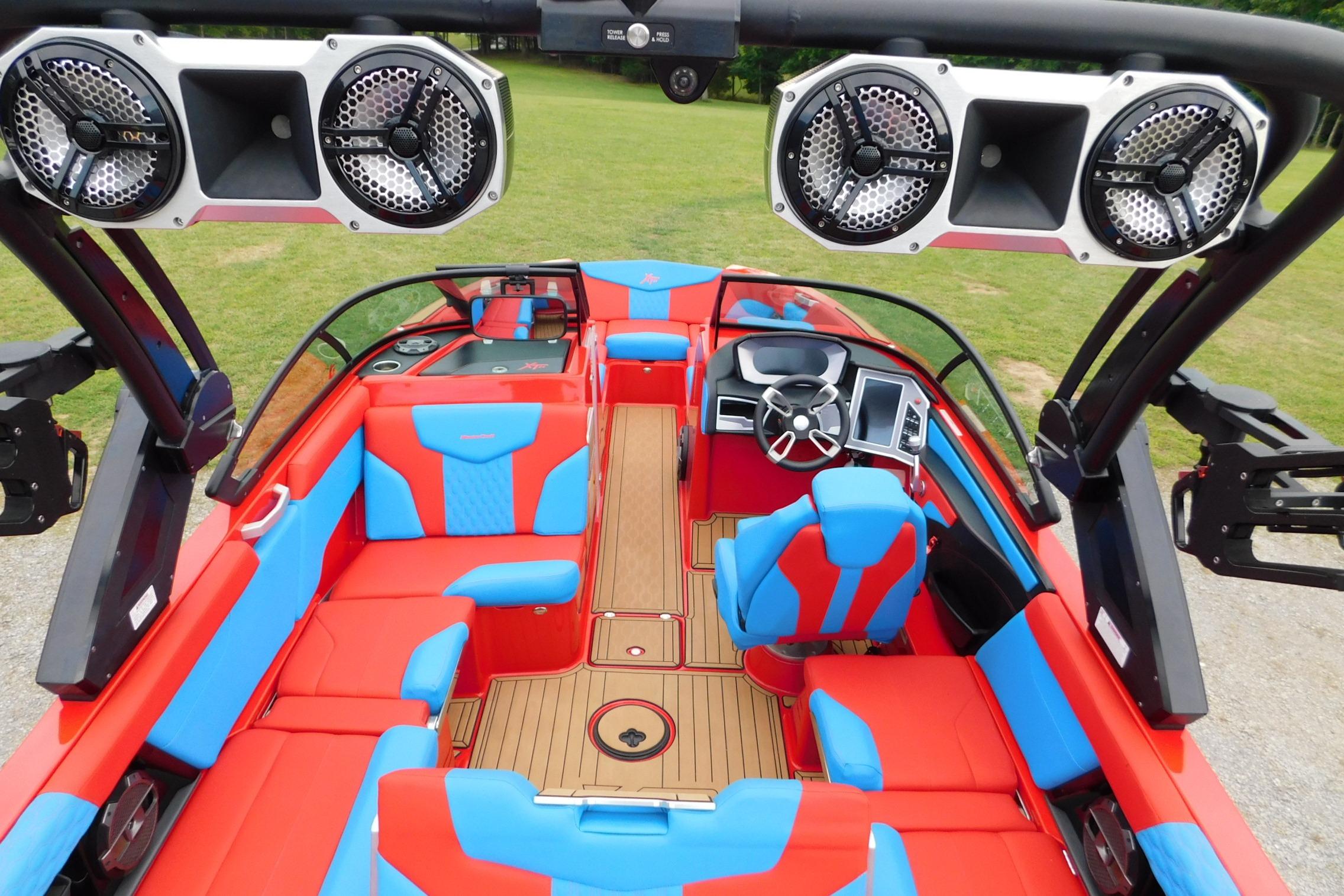 2022 MasterCraft NXT24 boat interior with vibrant red and blue seating, advanced sound system.