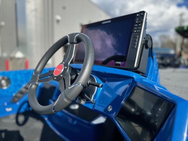 Close-up of 2024 iKon LX 20 boat dashboard with steering wheel and display.