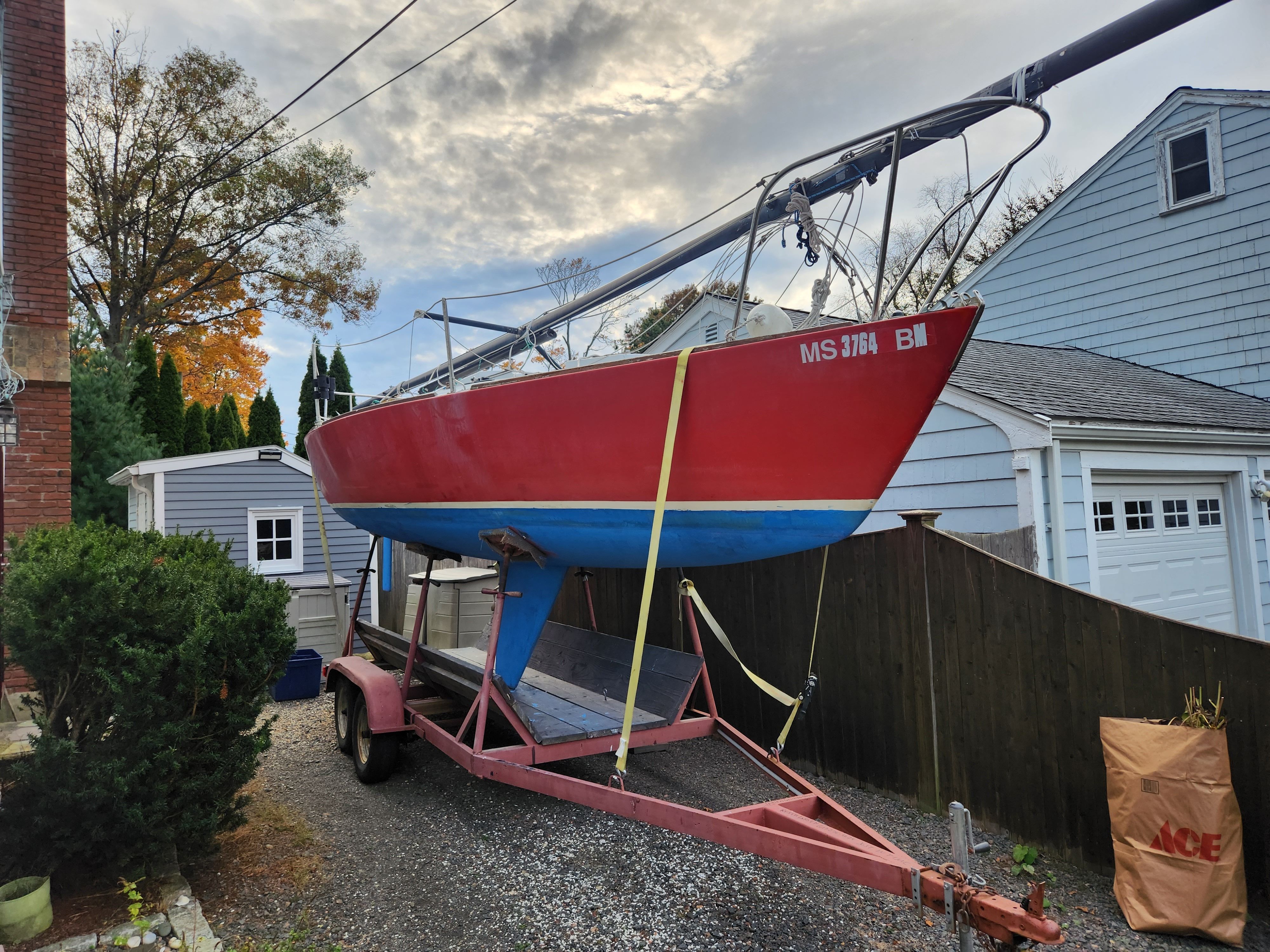1978 J Boats J/24 sailboat on trailer in a yard.