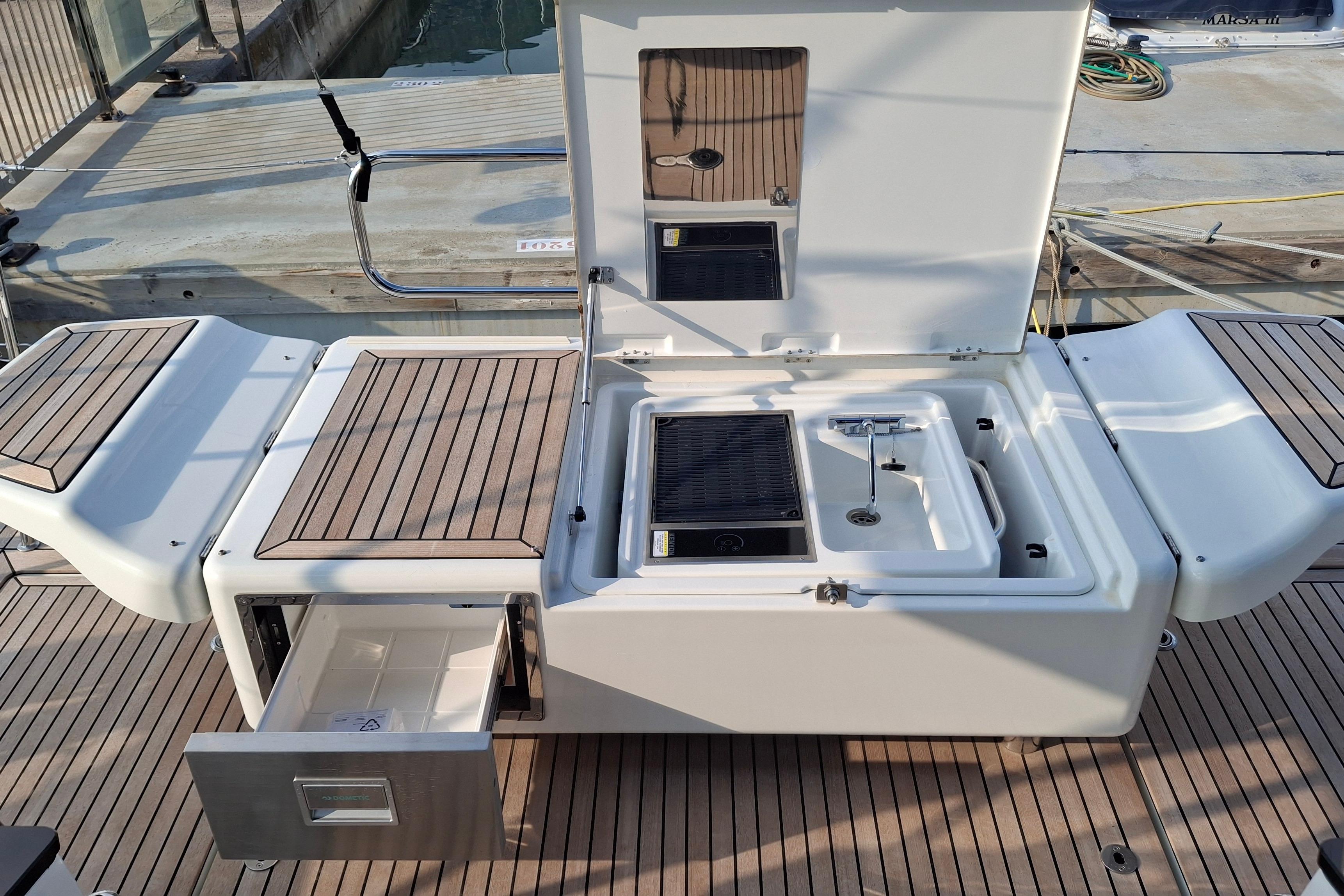 2025 Jeanneau 65 yacht deck with outdoor kitchen and storage compartments.
