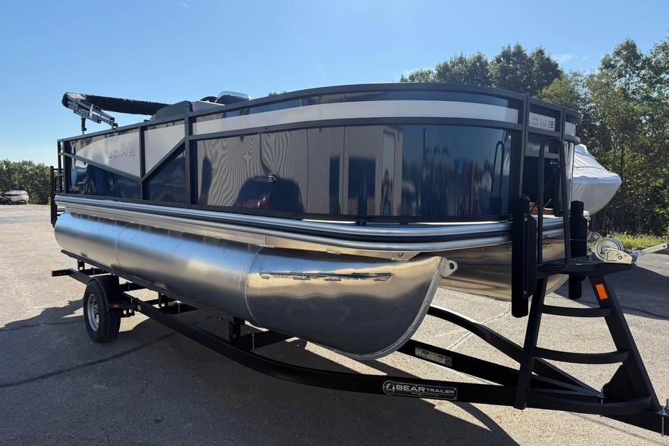 2026 Lowe LF 194 pontoon boat on trailer, parked outdoors under clear sky.