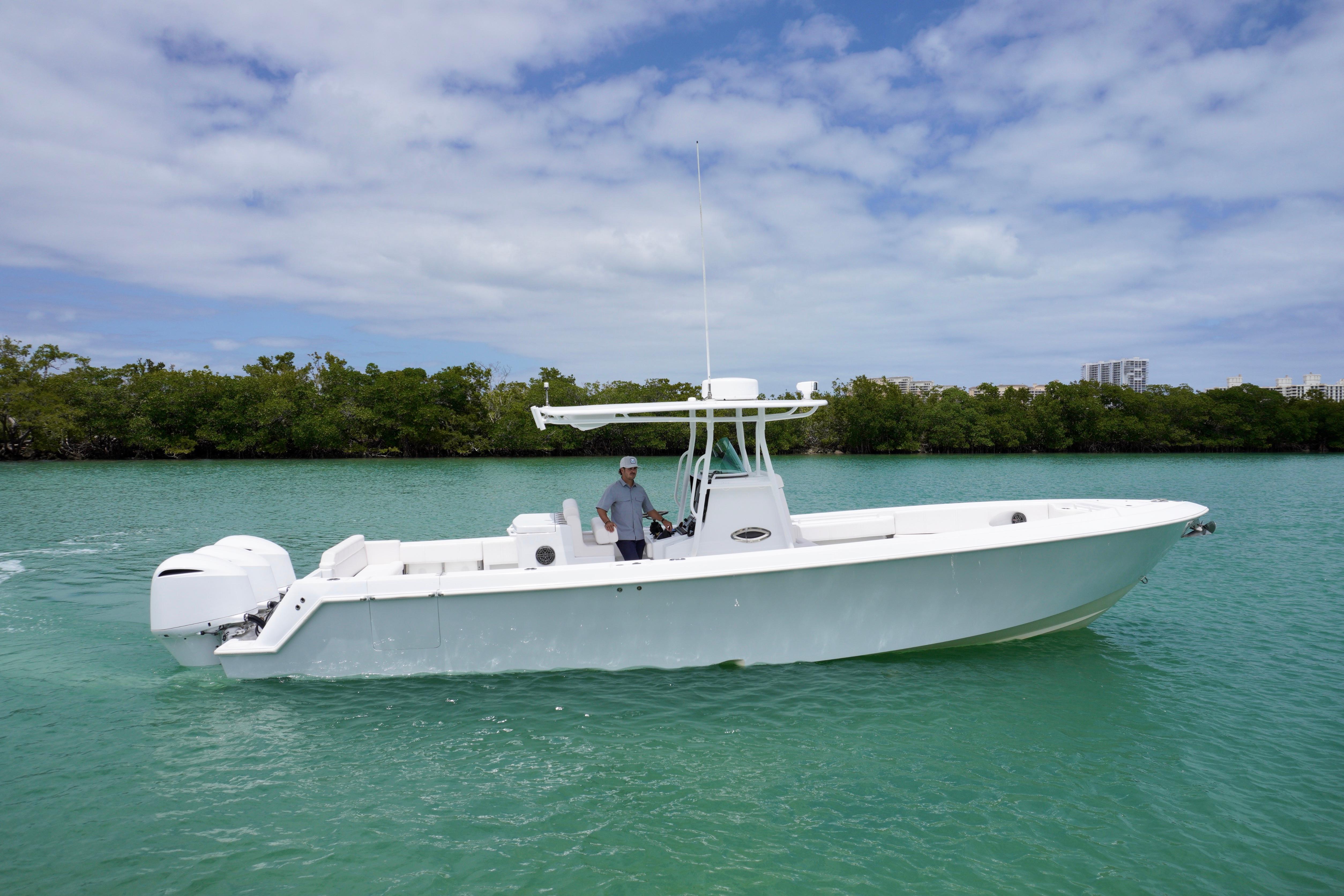 2013 Contender 35 LS boat on turquoise water, with lush greenery in the background.