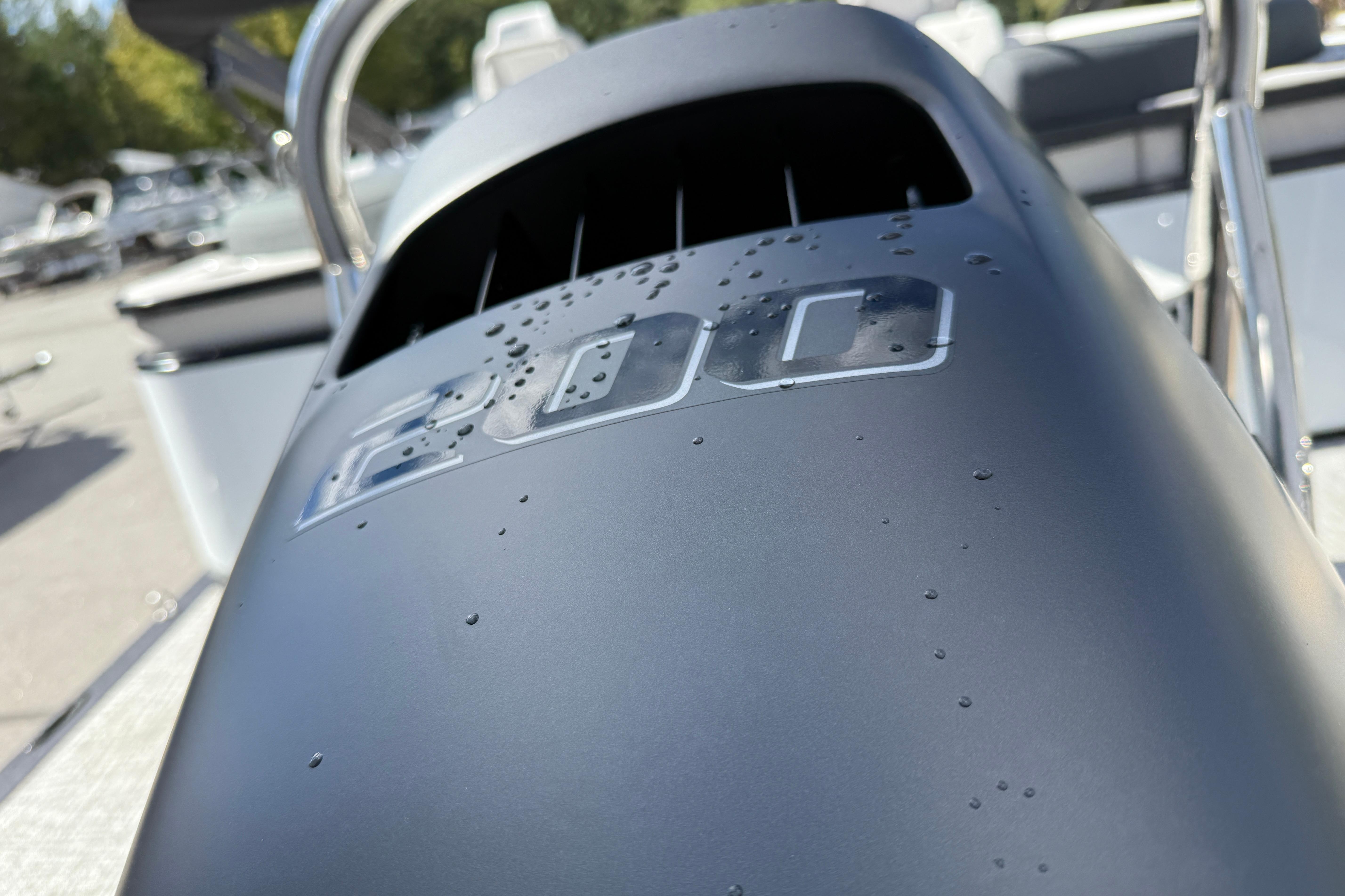 Close-up of 2026 Tahoe Pontoon LTZ Quad Lounger engine cover with water droplets.