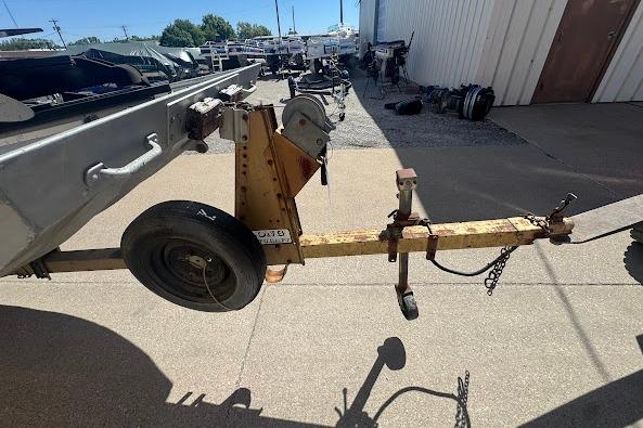 1973 Monark 14 Jon boat trailer hitch and wheel on concrete surface.