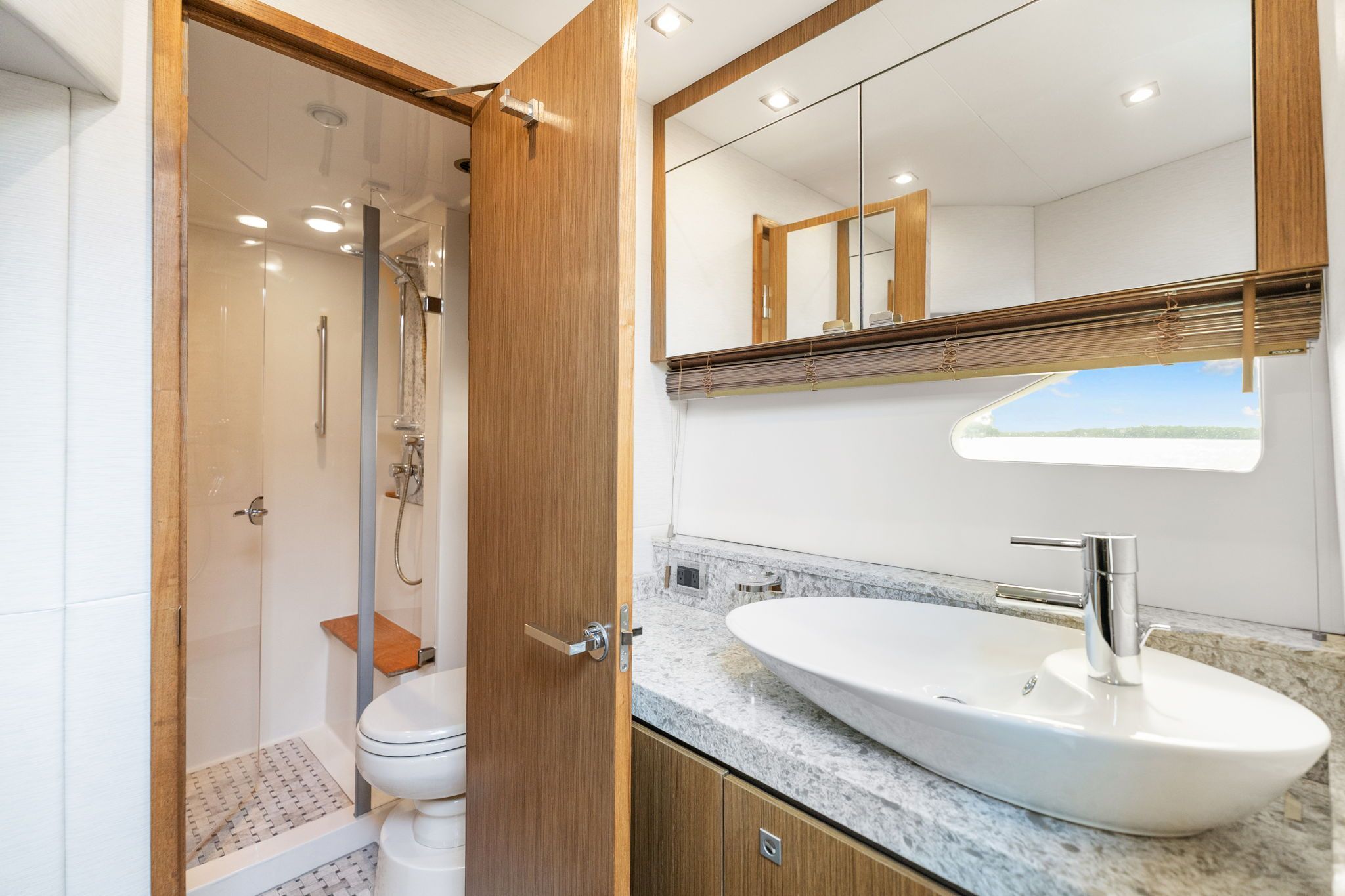 Bathroom with modern fixtures, sink, toilet, and shower in a Sea Ray Sundancer 510.