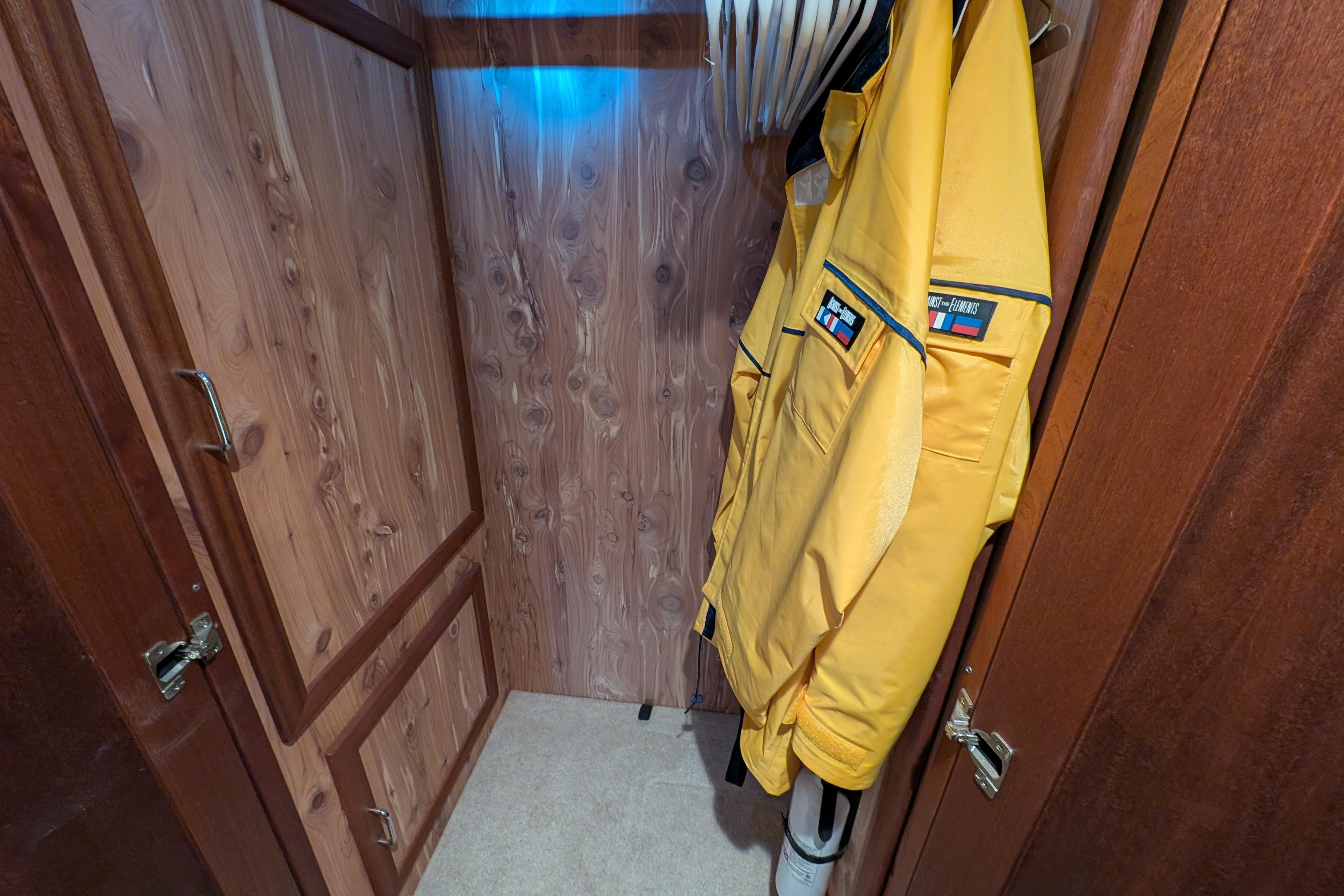 Wooden closet with yellow jacket on hanger, inside 2015 American Tug 435 boat.