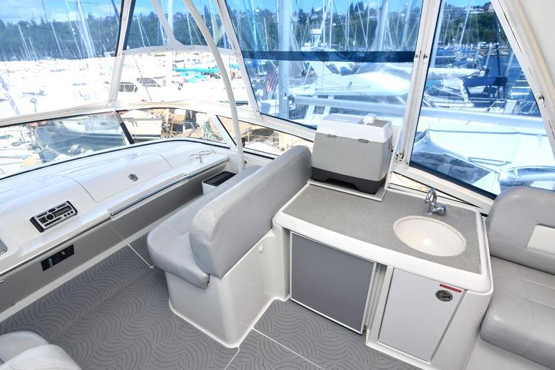 Interior of 2008 Carver 43 Super Sport yacht with seating, sink, and marina view.