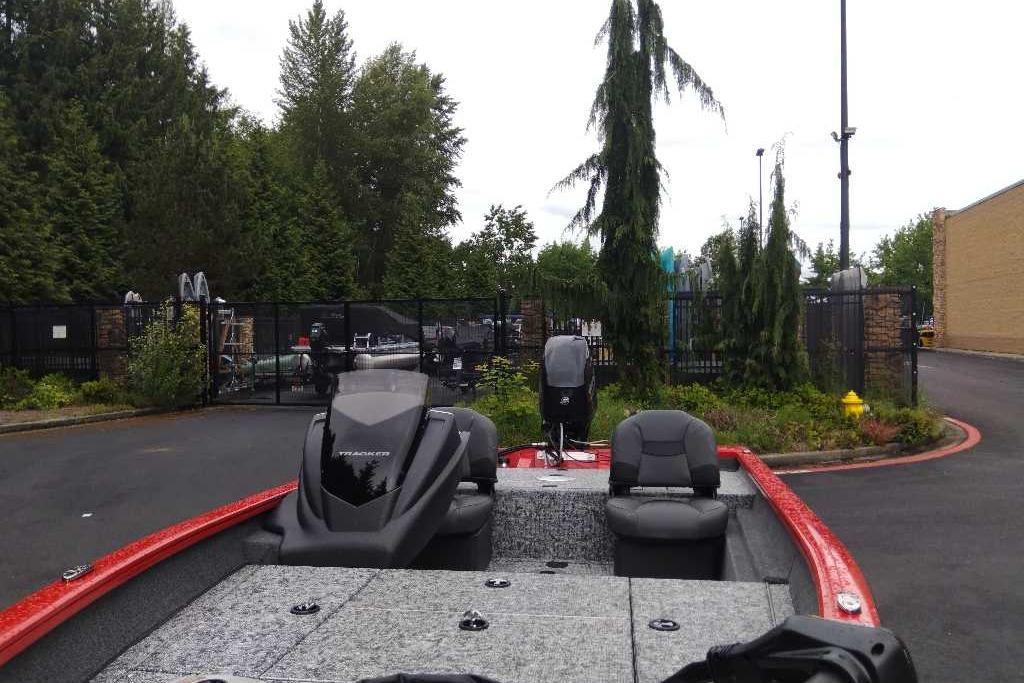 2026 Tracker Pro Team 175 Crappie Edition boat in a parking lot, surrounded by trees.