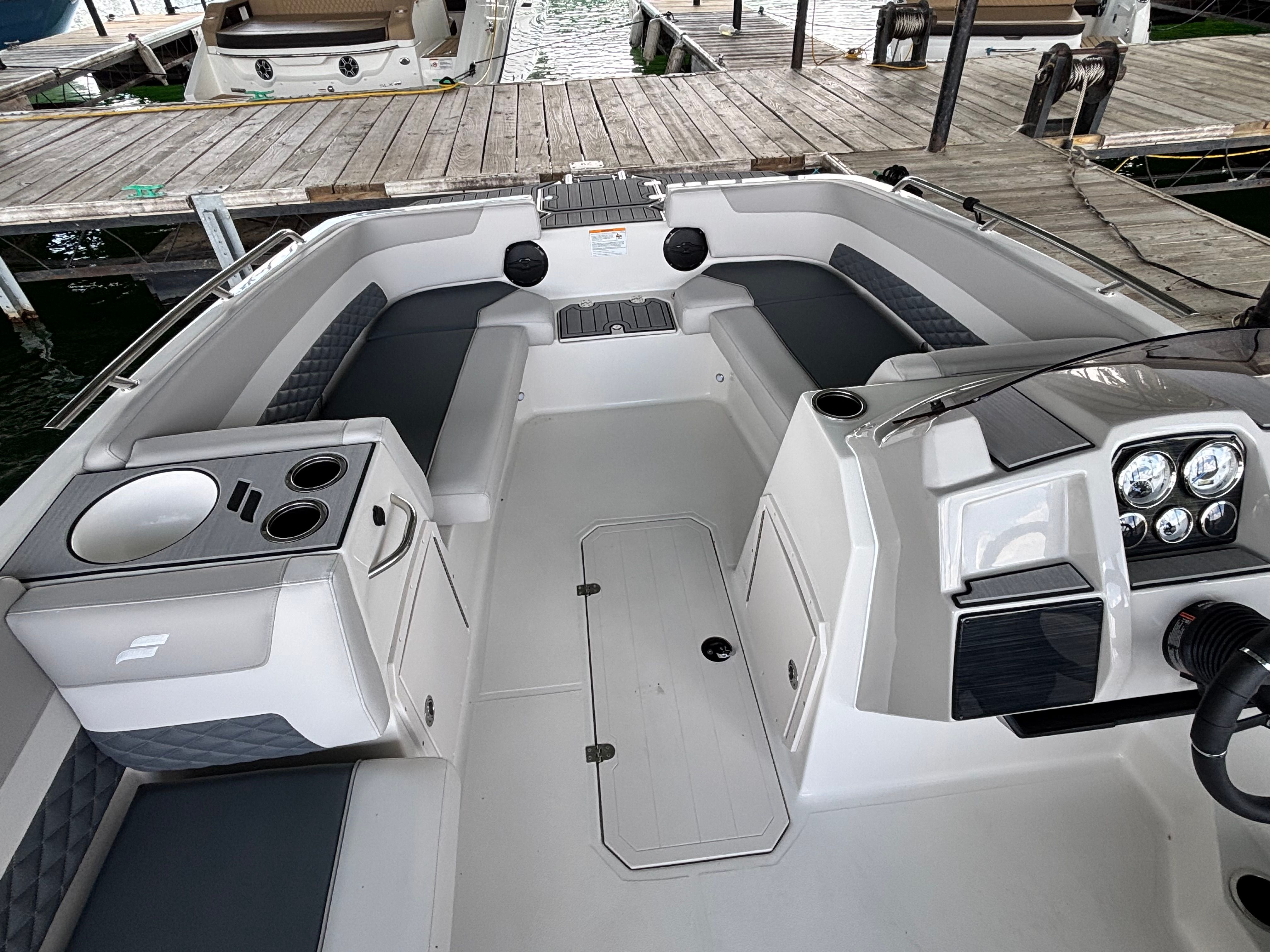 The image shows the cockpit of a 2027 Starcraft 211SVXOB boat with gray seating.