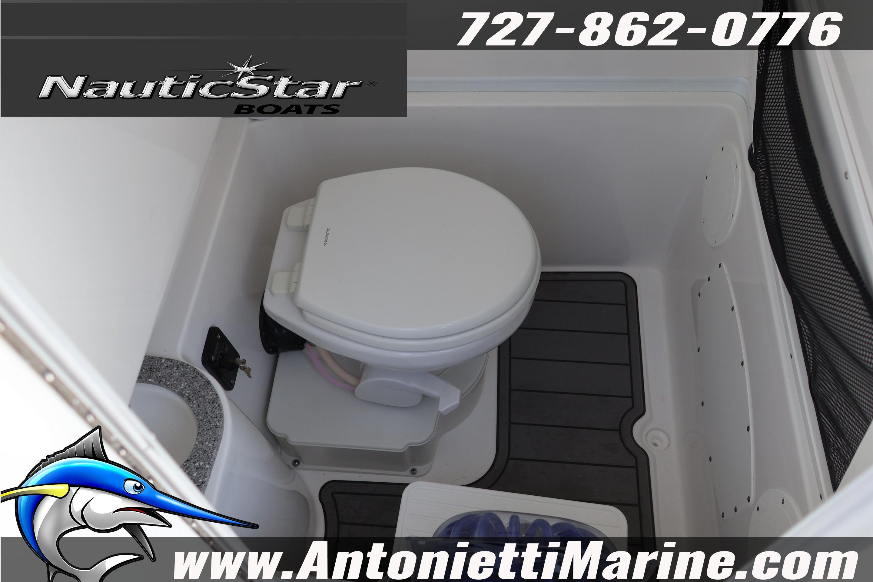 Interior of 2026 NauticStar 292 Legacy boat featuring a compact marine toilet.