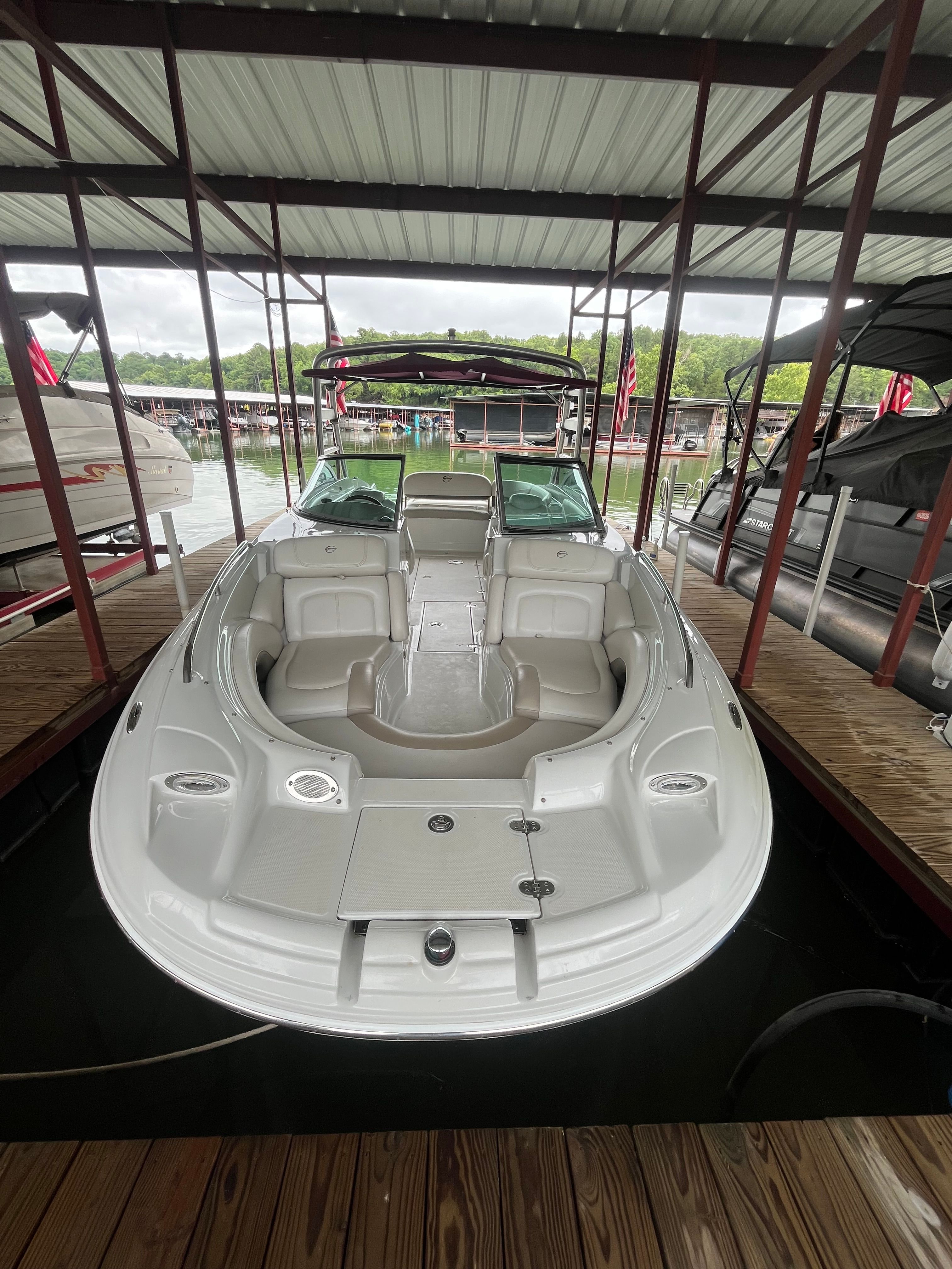 A 2008 Crownline 252EX boat is docked under a covered area. It features an open cabin.