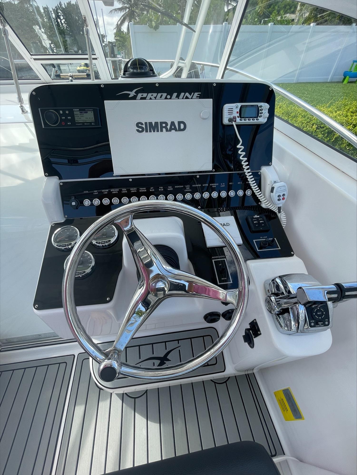 The helm of a Pro-Line 32 Express boat with modern navigation equipment.