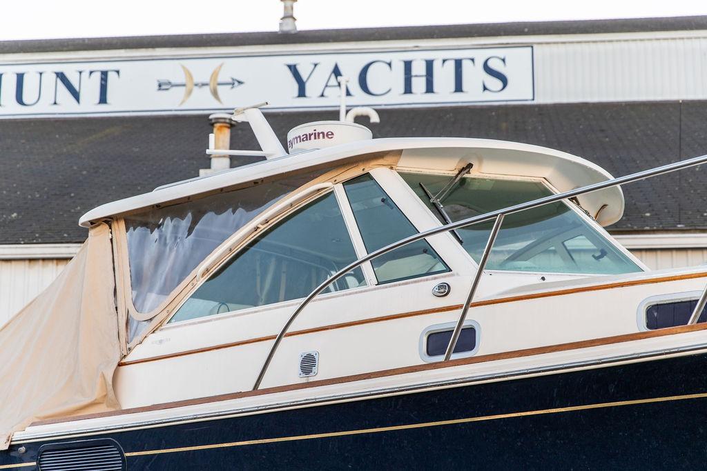 2008 Hunt Yachts Surfhunter 29 boat at dockside, featuring sleek design and cabin enclosure.