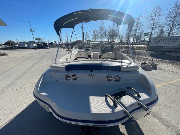 2012 Tahoe Q4 SS boat with canopy, parked outdoors on a sunny day.