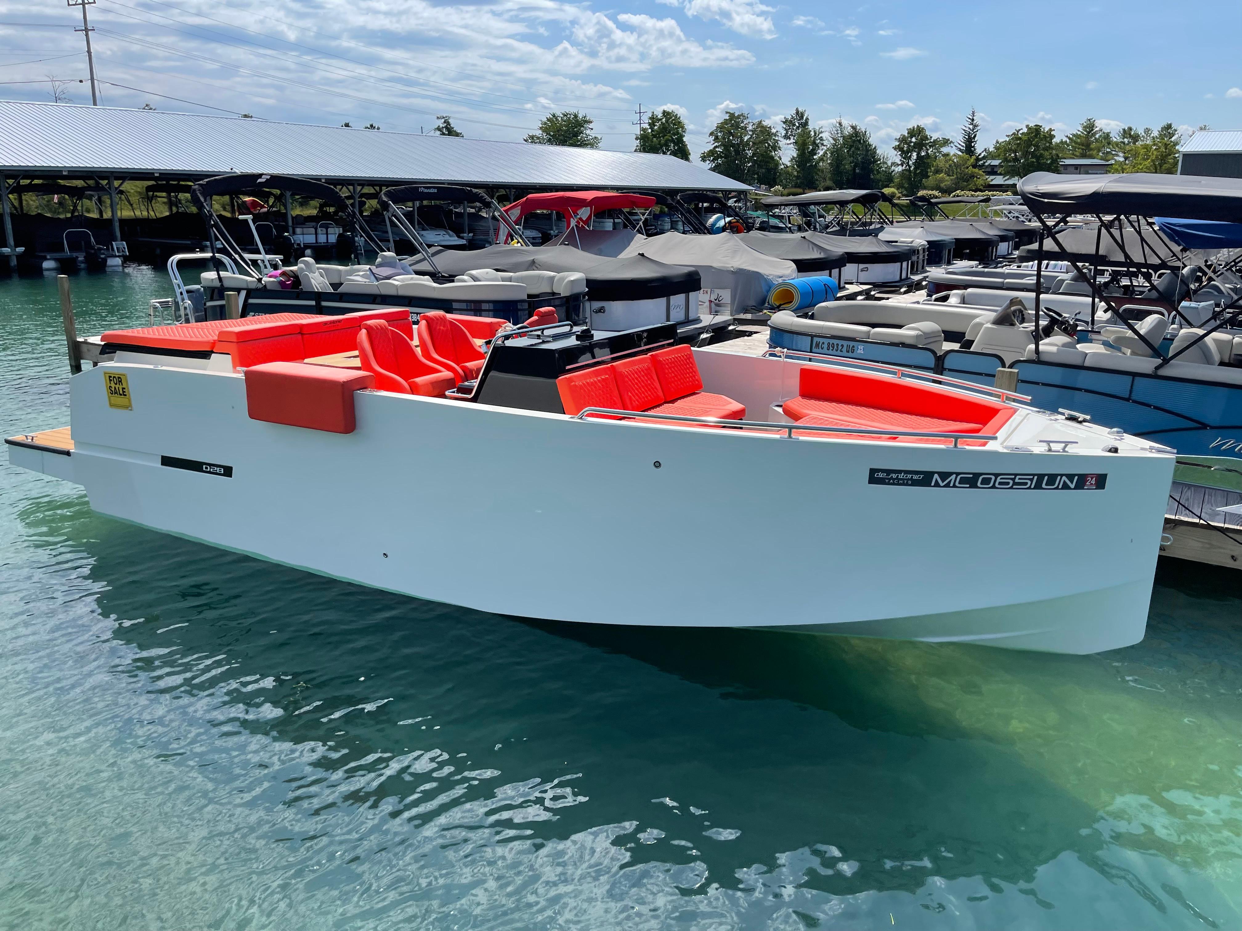 2020 De Antonio Yachts D 28 with red seating, docked in a marina.