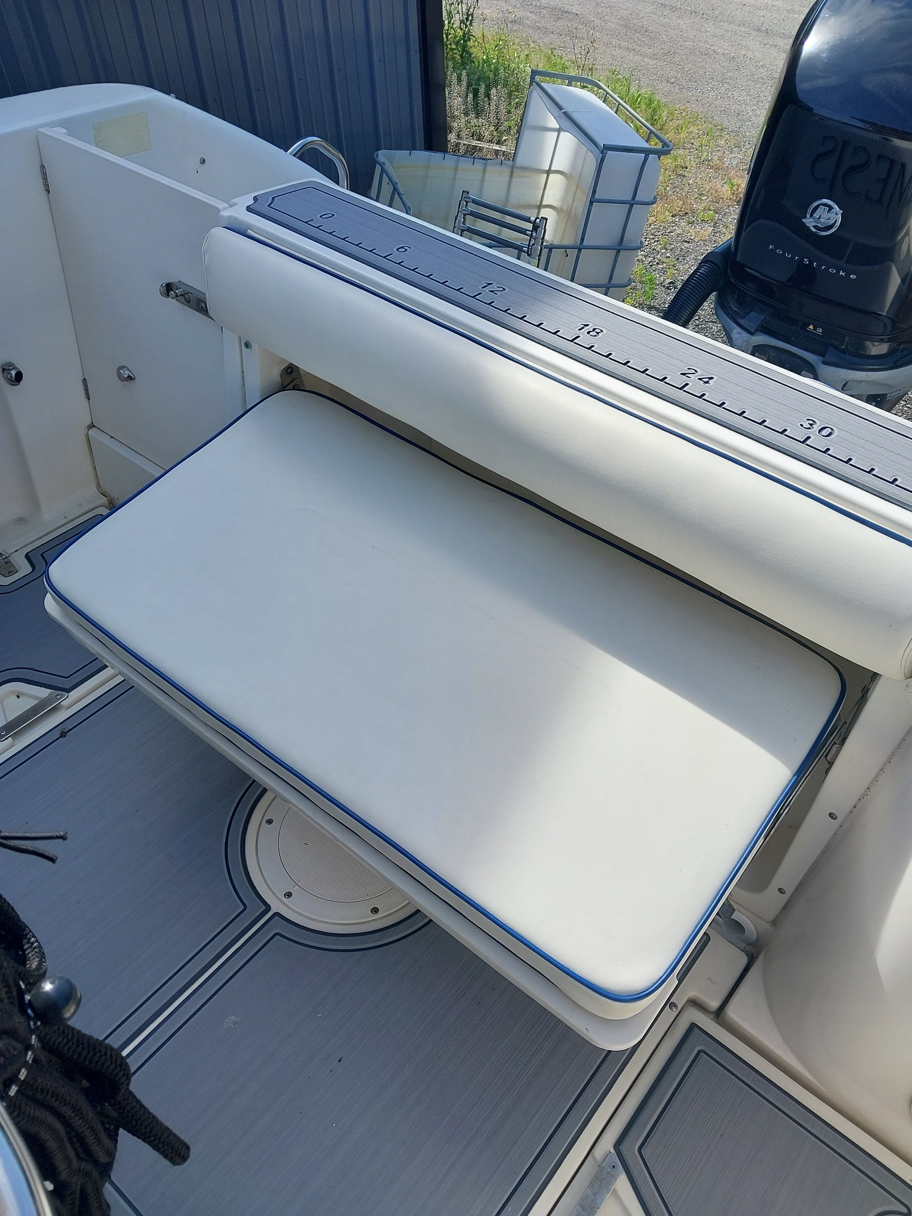 The 2005 Boston Whaler 240 Outrage features a cushioned bench seat and an outboard motor.