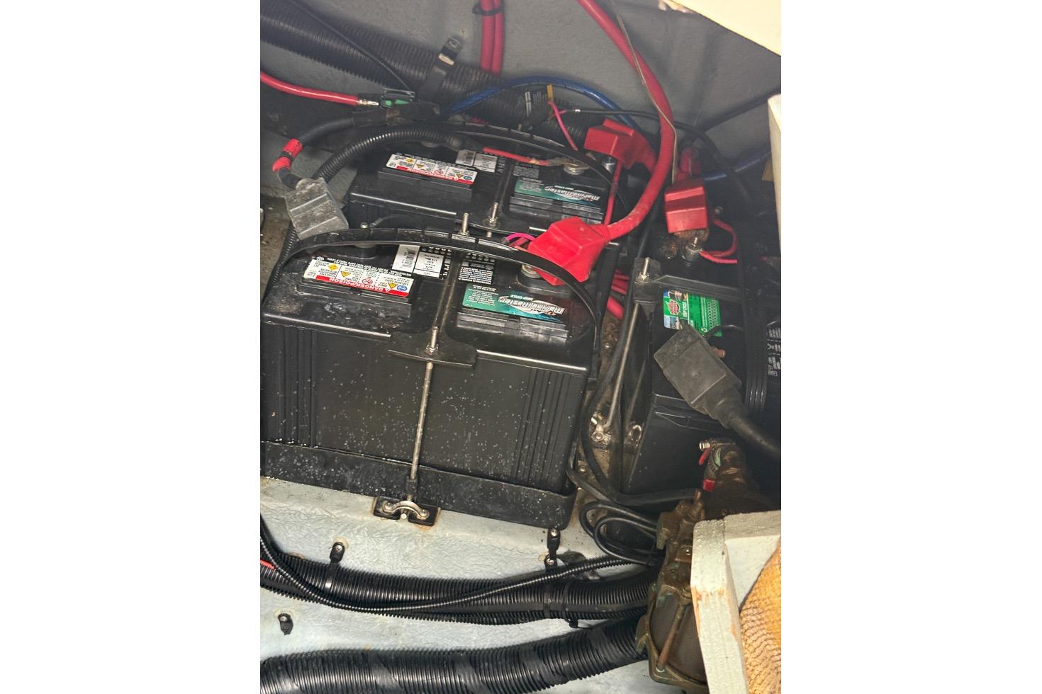 Battery compartment of a 1999 Sea Ray 290 Sundancer with wiring and connections.