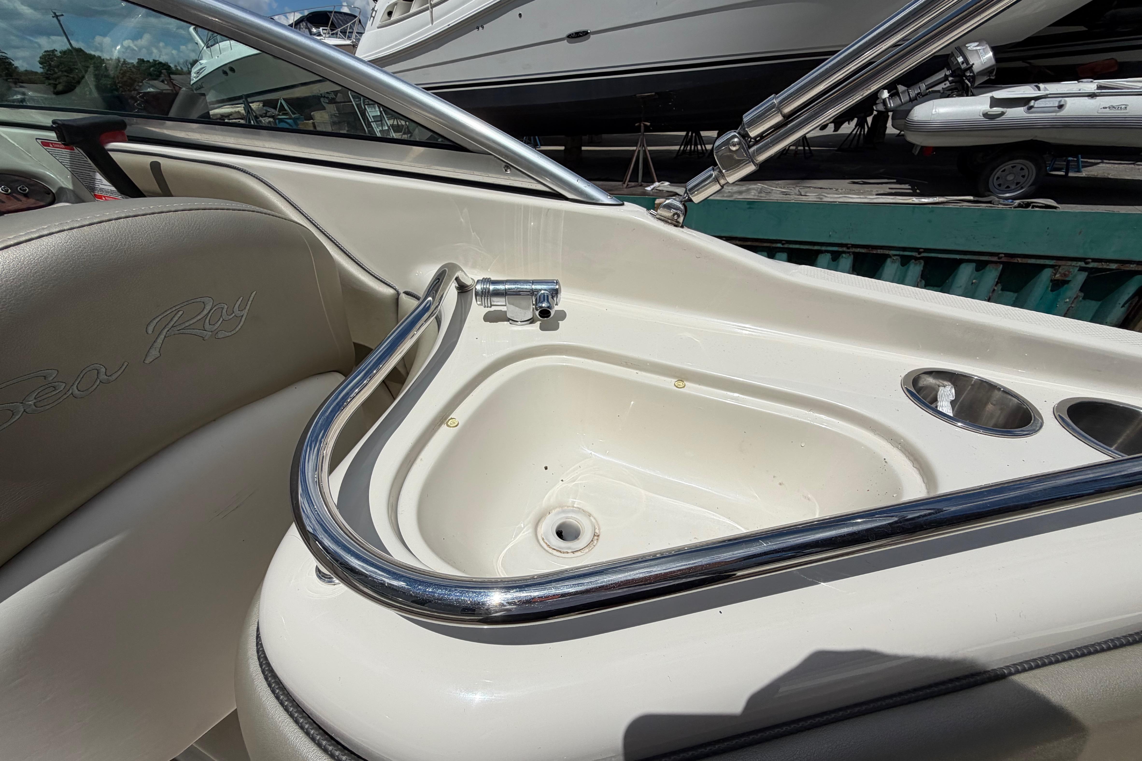 2004 Sea Ray 240 Sundeck boat interior with sink and cup holders.