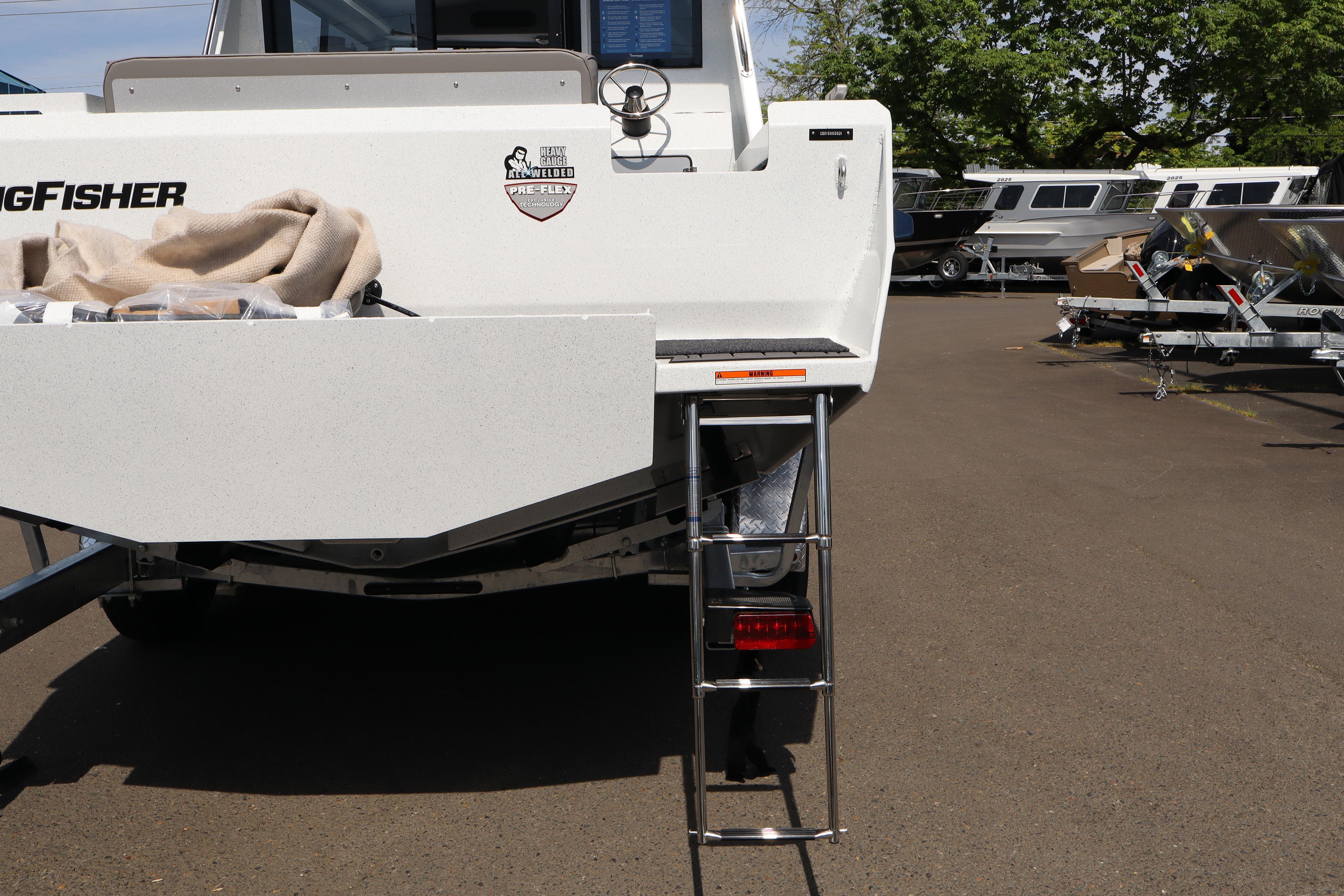 Rear view of a 2026 KingFisher 25 XAC boat with ladder and trailer.