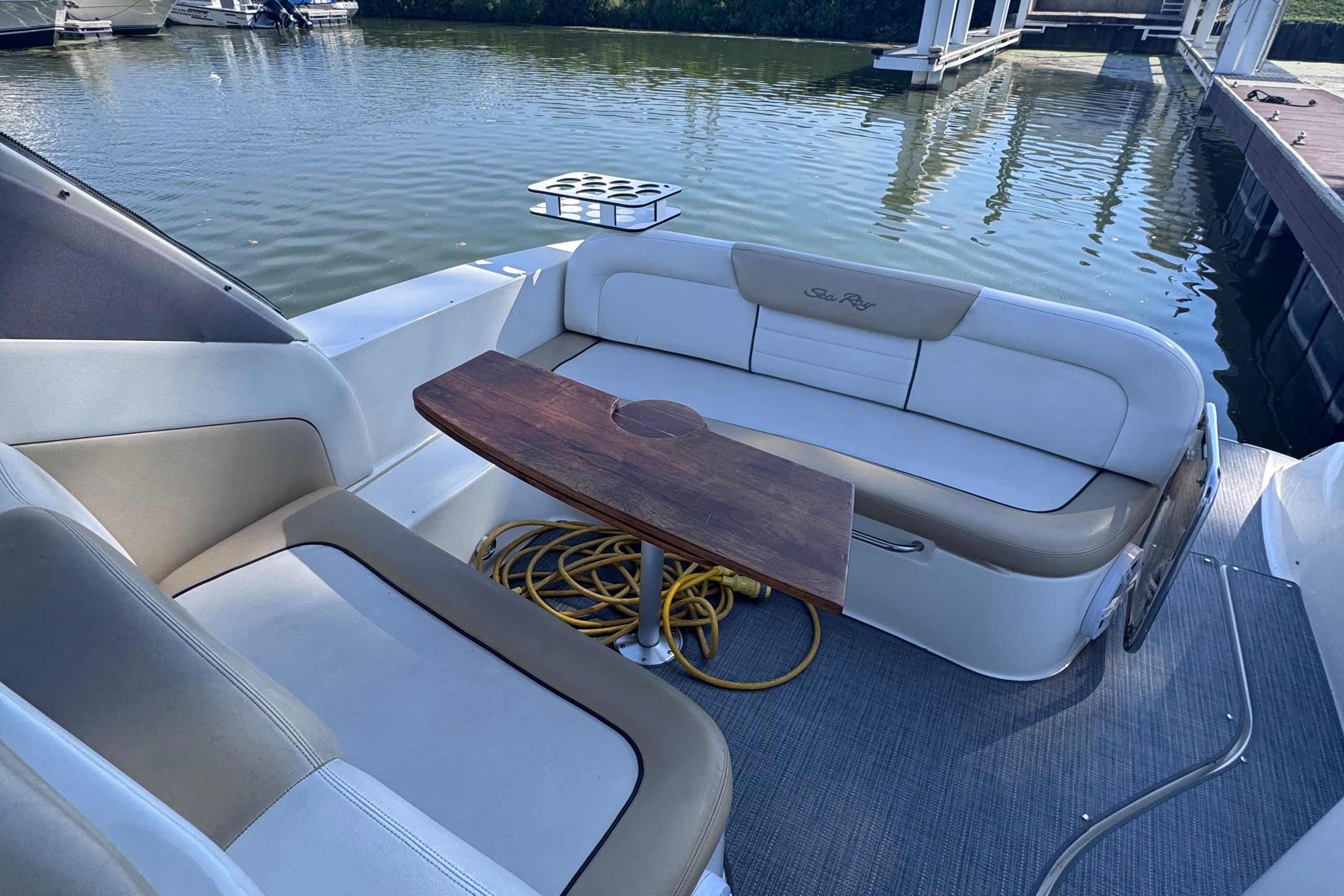2008 Sea Ray 350 Sundancer boat interior with seating and wooden table, docked by the water.