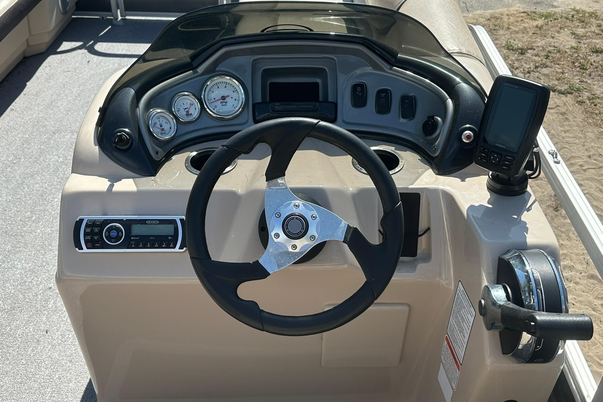 2016 SUNTRACKER Party Barge 20 dashboard with steering wheel and control panel.