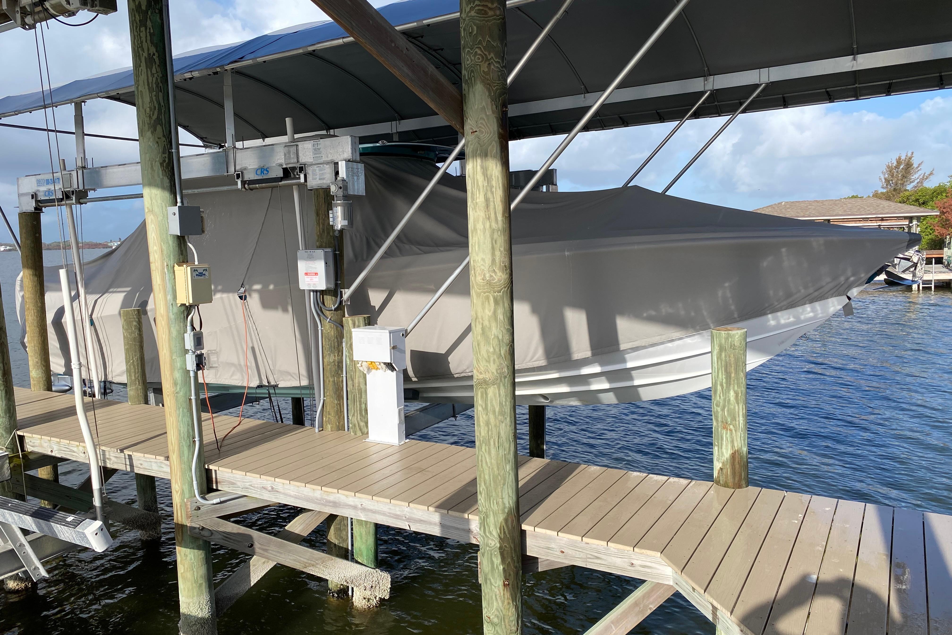2018 Nor-Tech 340 Sport Center Console boat covered and docked on a lift.