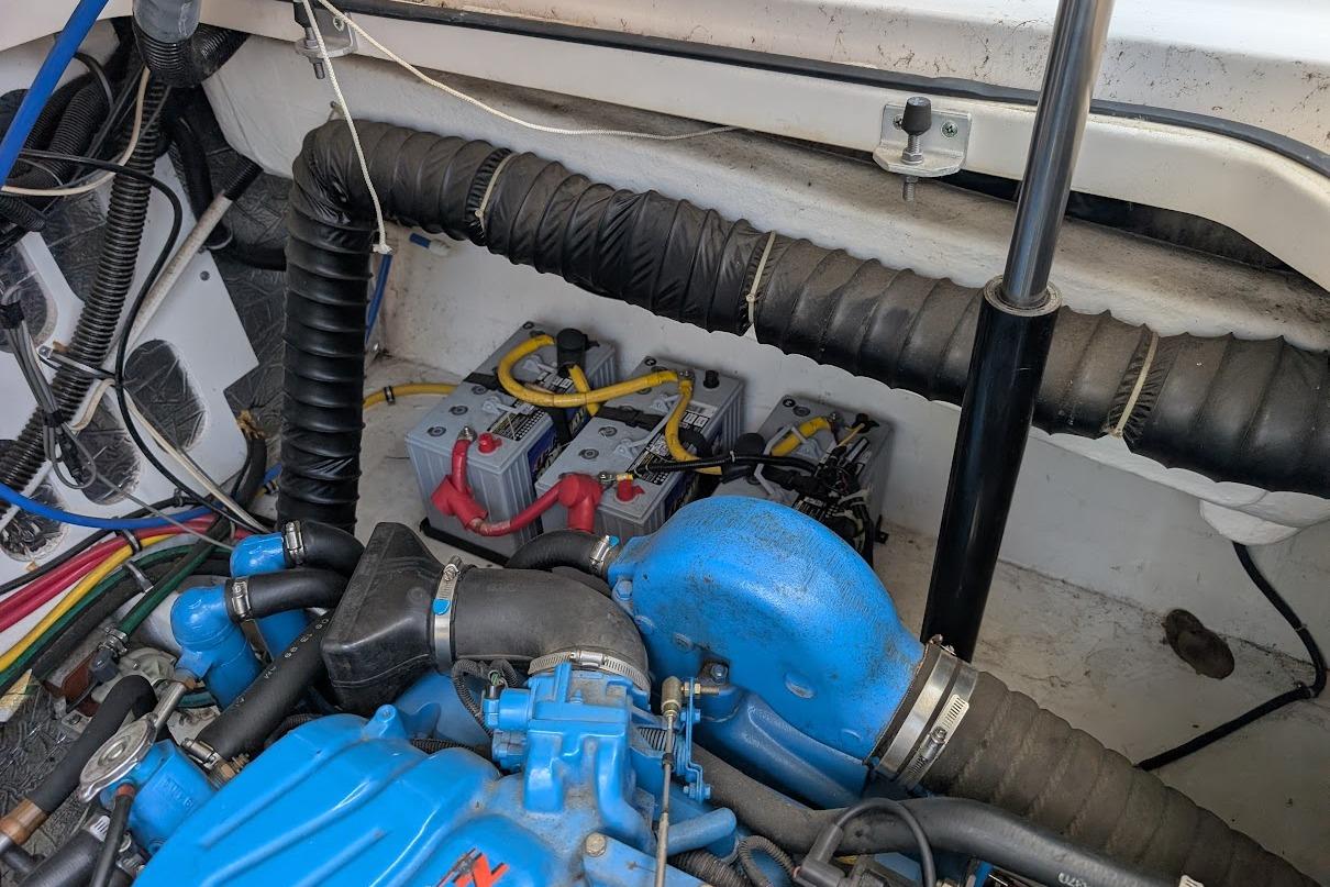 Engine compartment of a 2000 Pursuit 3400 Express boat with visible wiring and batteries.