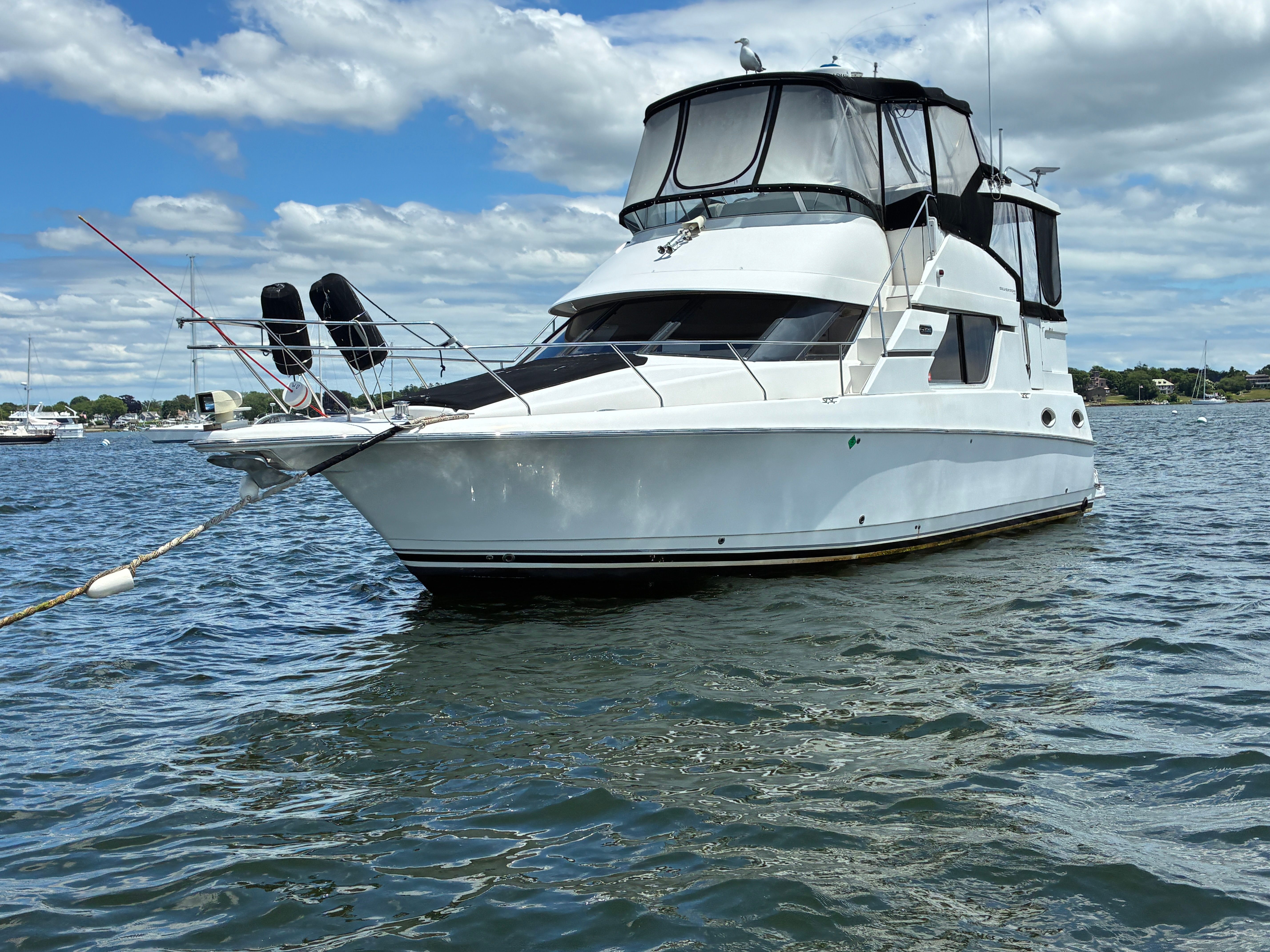 A 2001 Silverton 392 Motor Yacht floats on calm water under a cloudy sky.