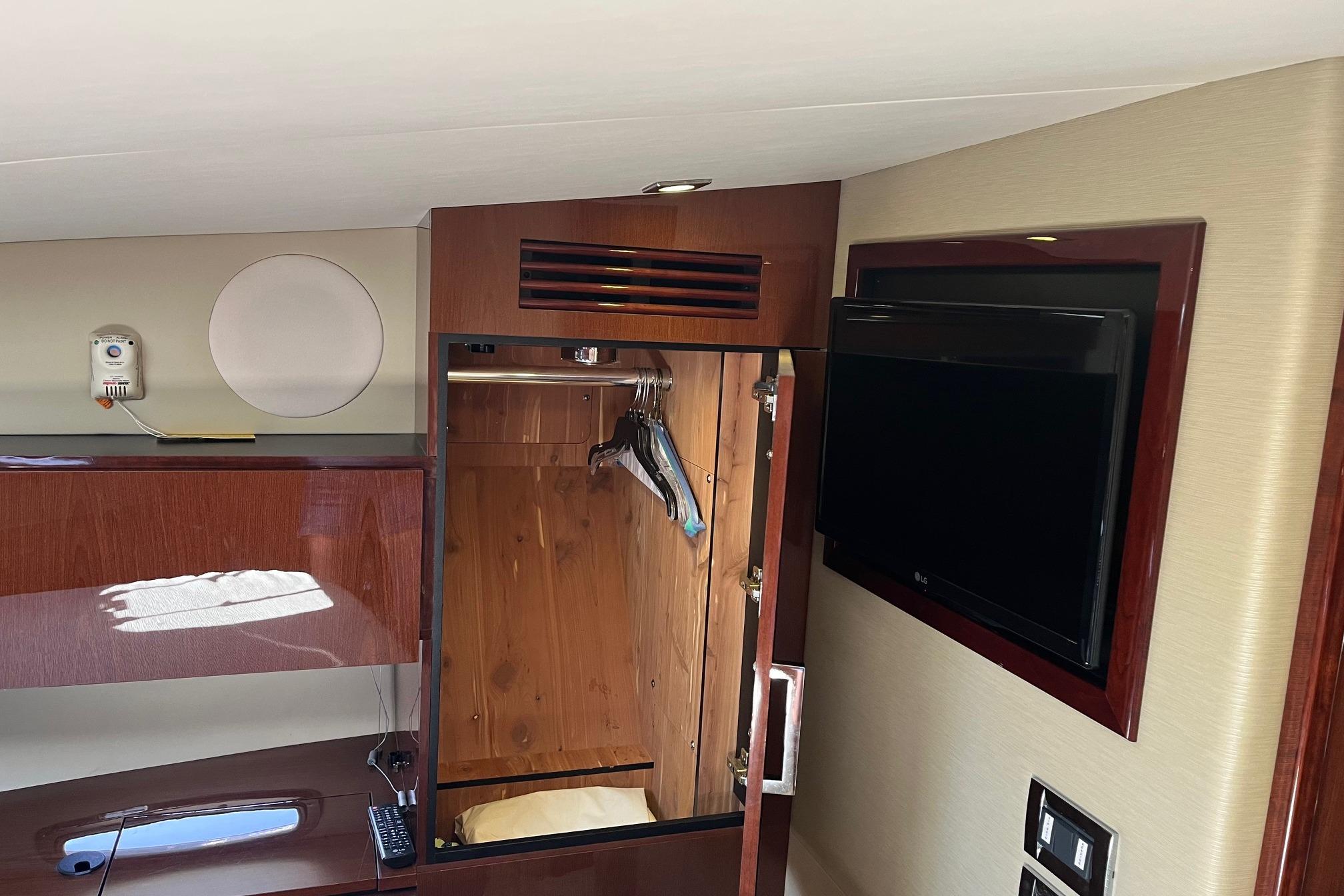2015 Sea Ray 470 Sundancer interior with wooden closet and wall-mounted TV.