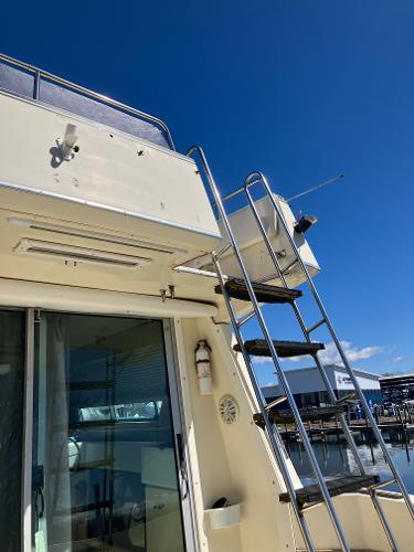 1985 Cruisers Yachts 338 Chateau Vee, exterior view with ladder and upper deck.