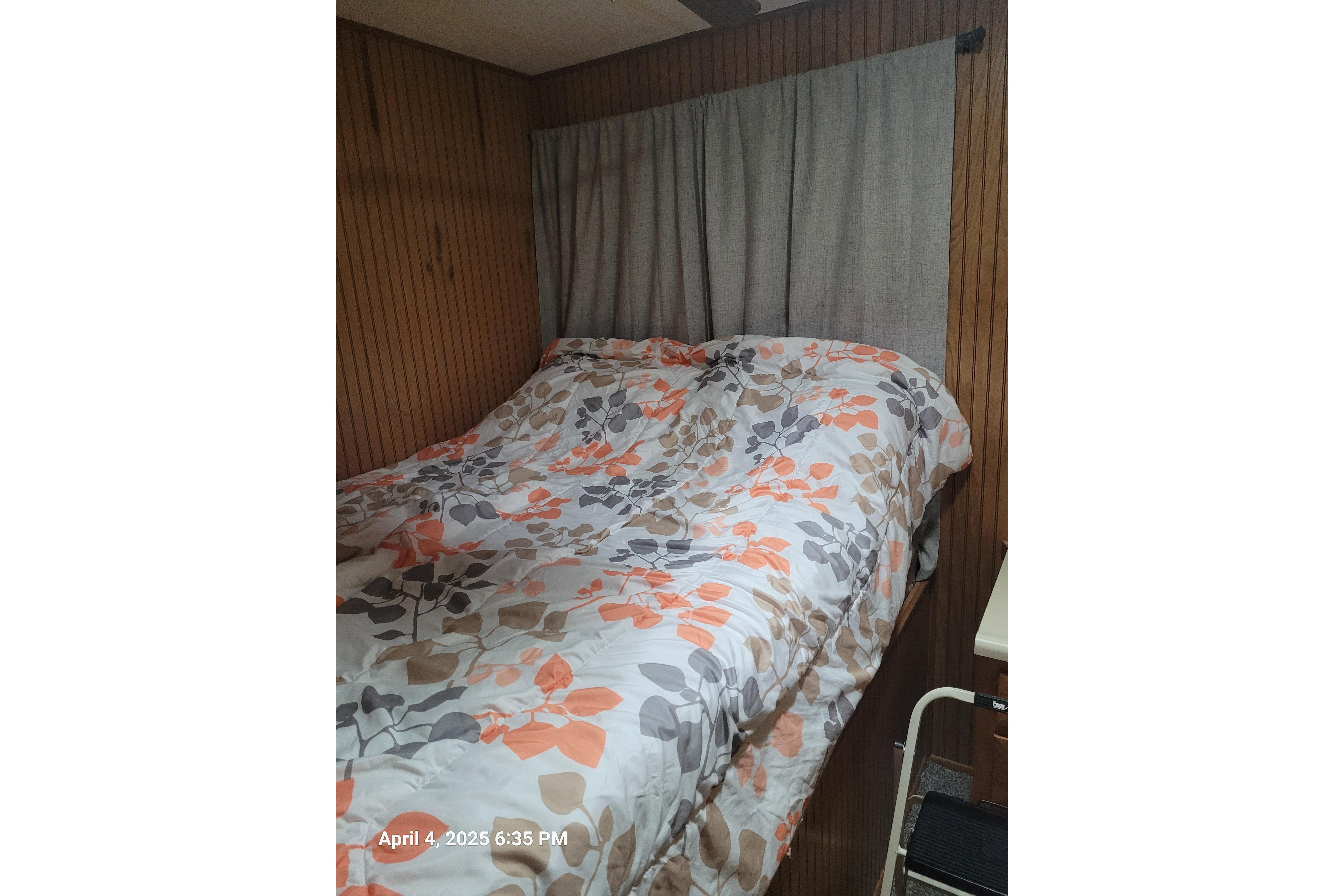 Cozy bedroom with floral bedding in a 1990 Sumerset 16 x 70 houseboat.