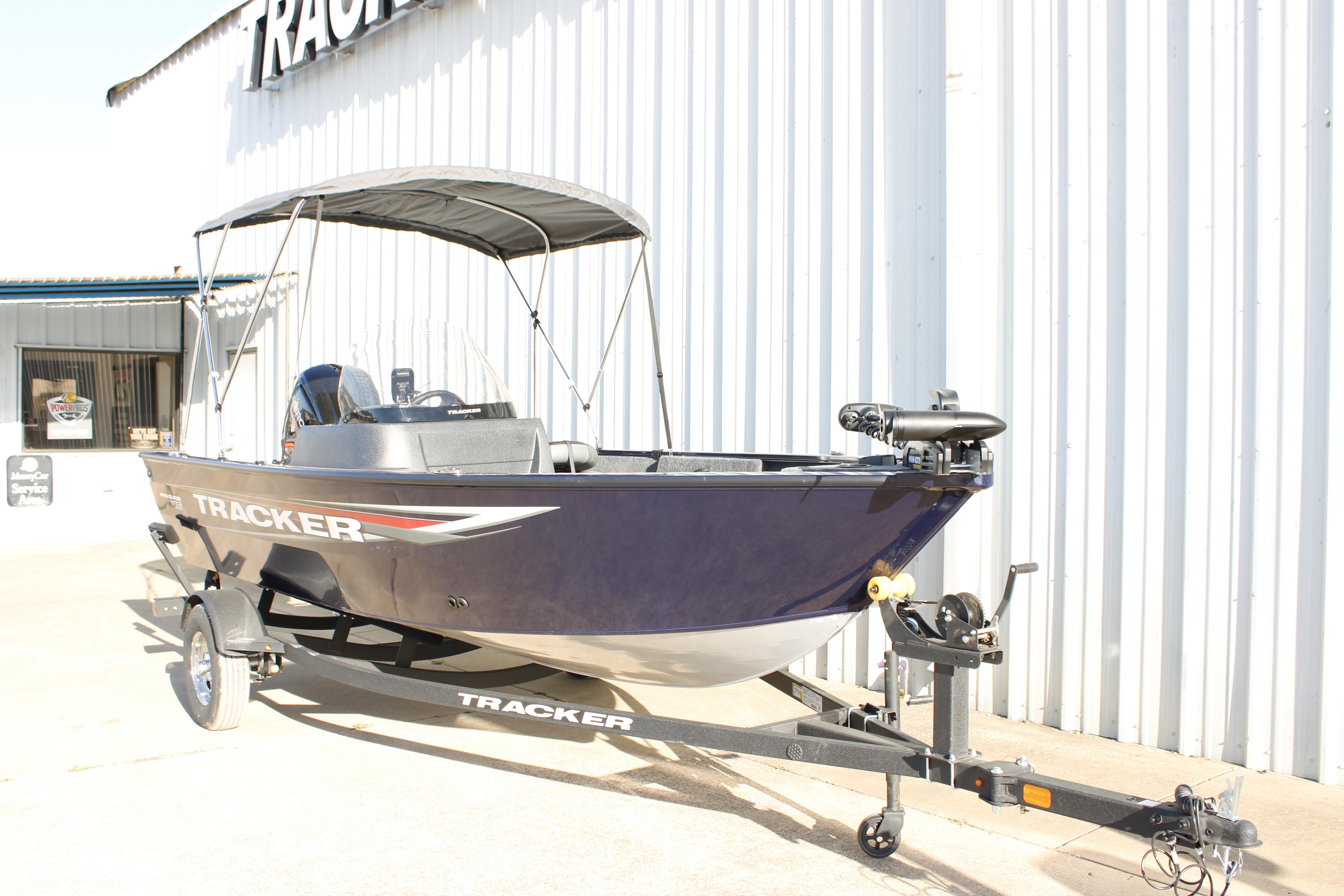 2026 Tracker Pro Guide V-16 SC boat with canopy on trailer, parked outside.