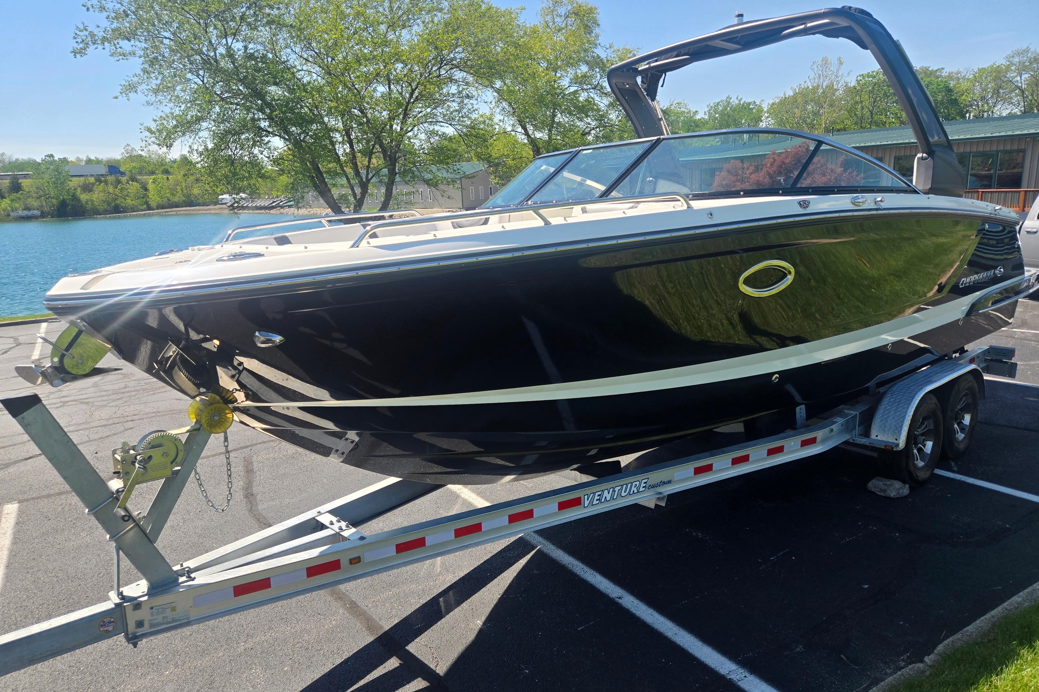2018 Chaparral 267 SSX boat on trailer, parked near a scenic lake.