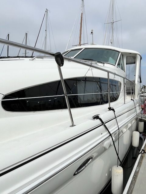 A 2004 Sea Ray Sedan Bridge docked at a marina. It features a sleek, white design.