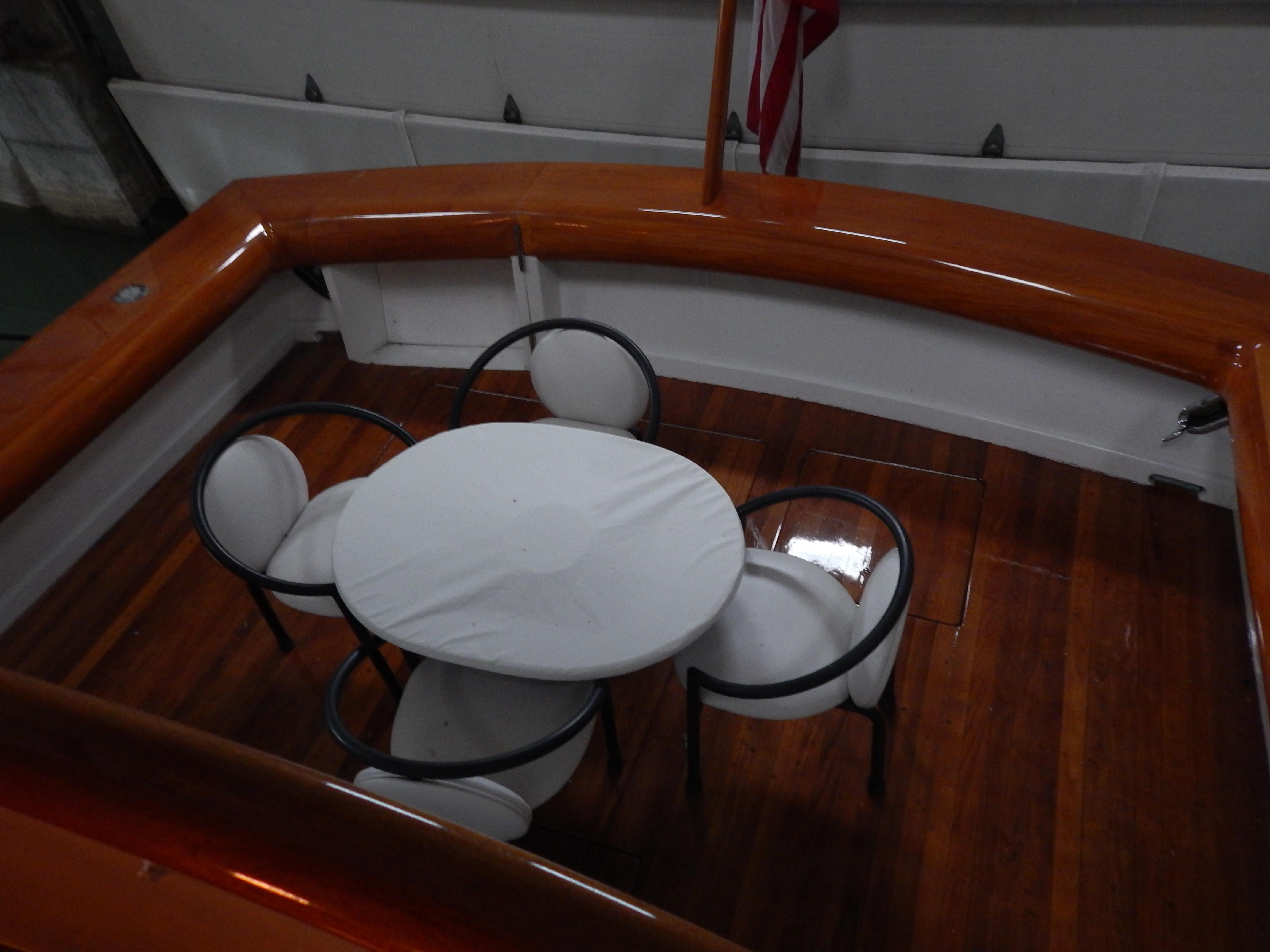 1974 Pacemaker Cockpit Motoryacht with elegant wooden deck and round table seating.
