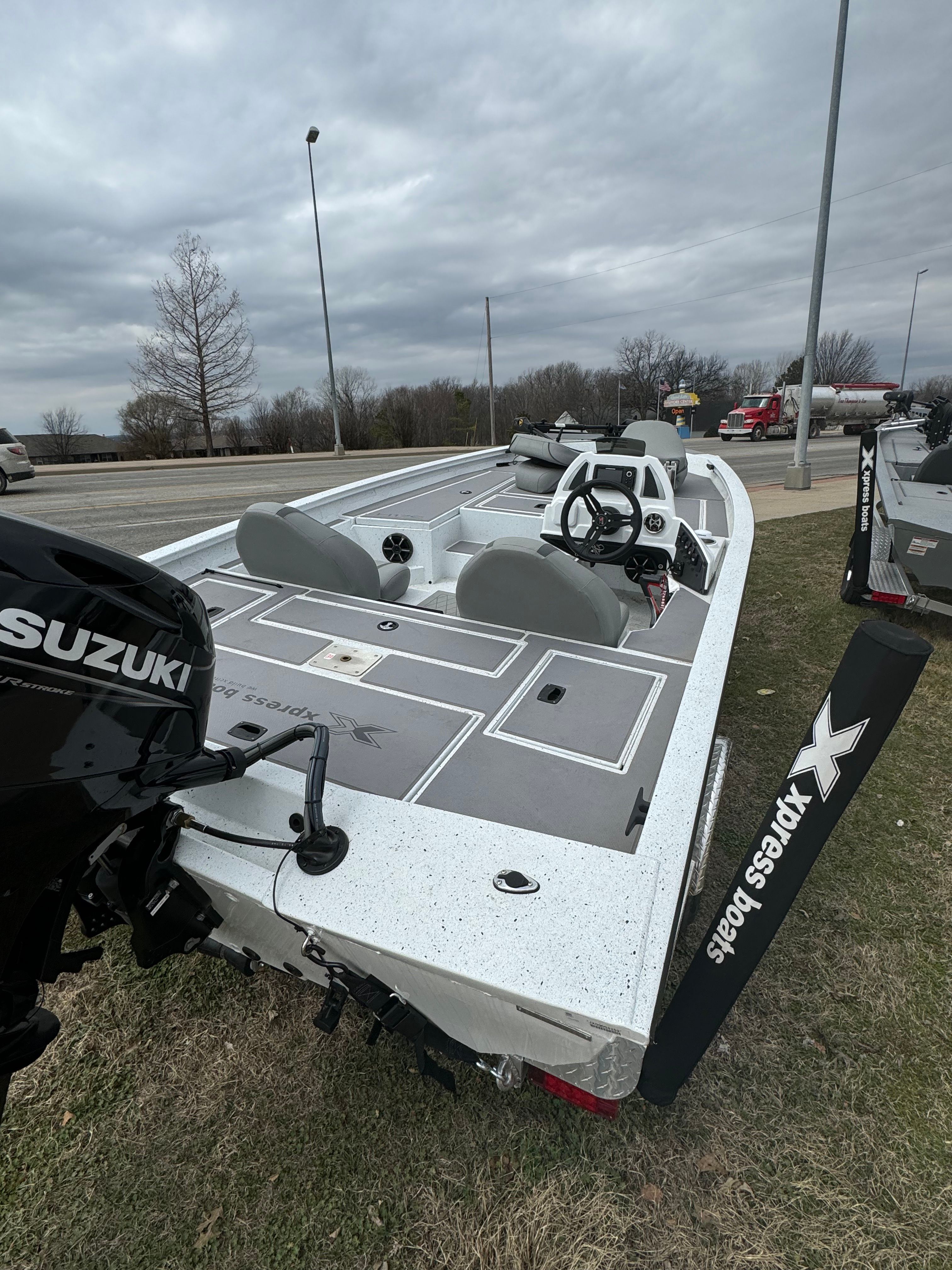 2024 Xpress H17C Crappie boat with Suzuki motor on grass.