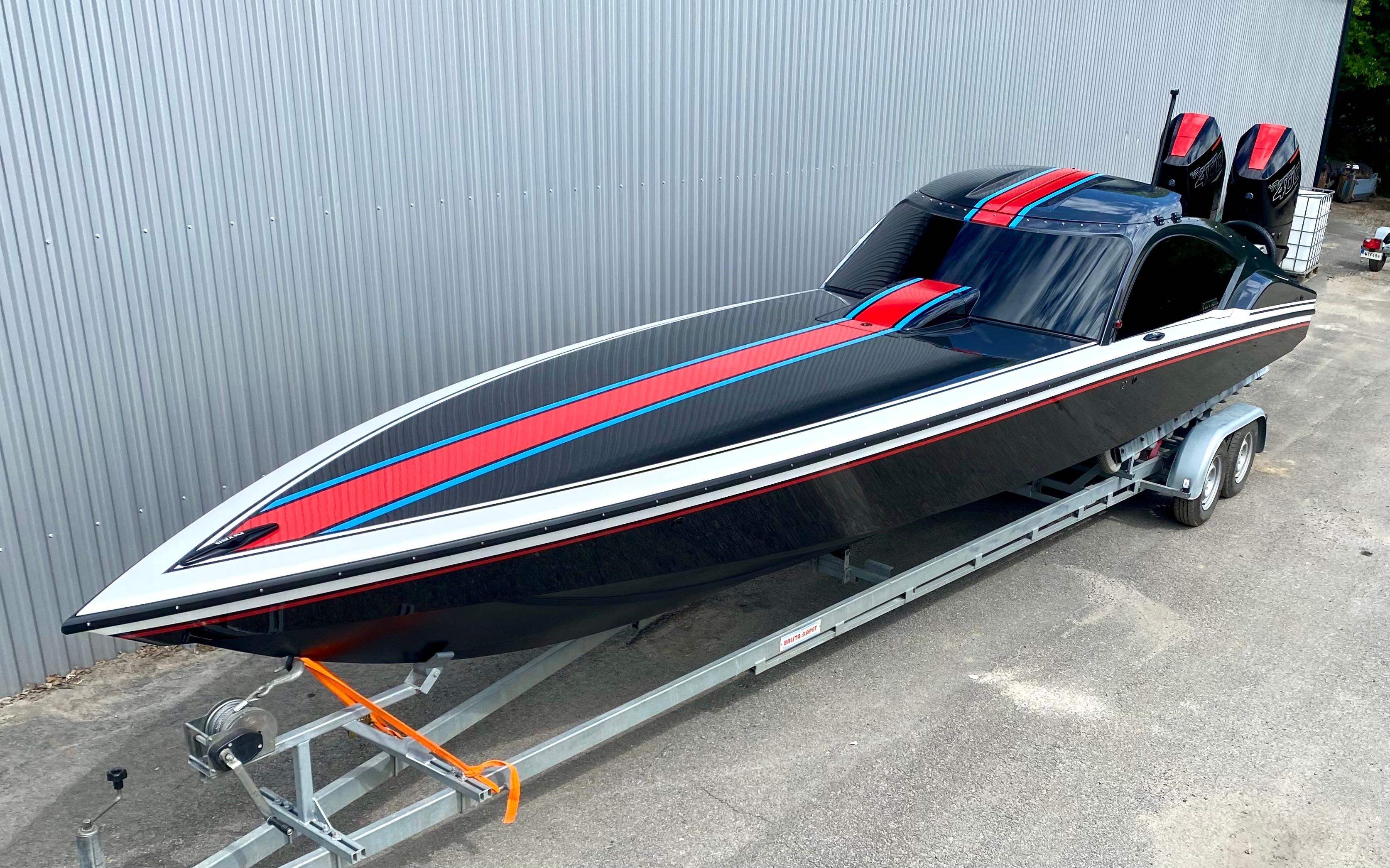 2024 Nitra Boats 30 SkyTop on trailer, sleek black design with red and blue accents.