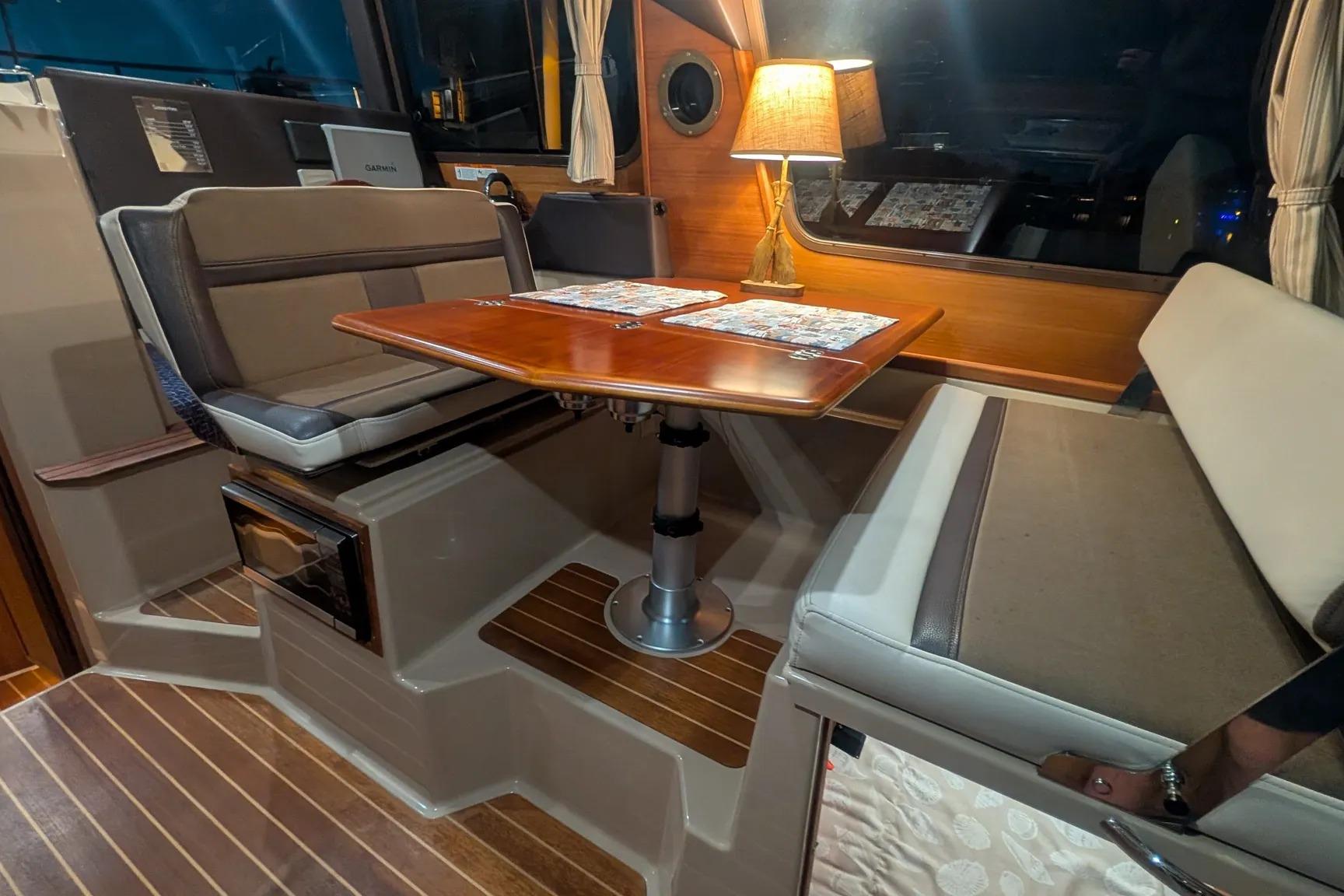 Interior of 2015 Ranger Tugs R-29 S with cozy dining area and ambient lighting.