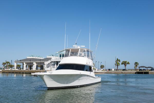 1999 Viking 47 Convertible yacht on calm water near a marina.