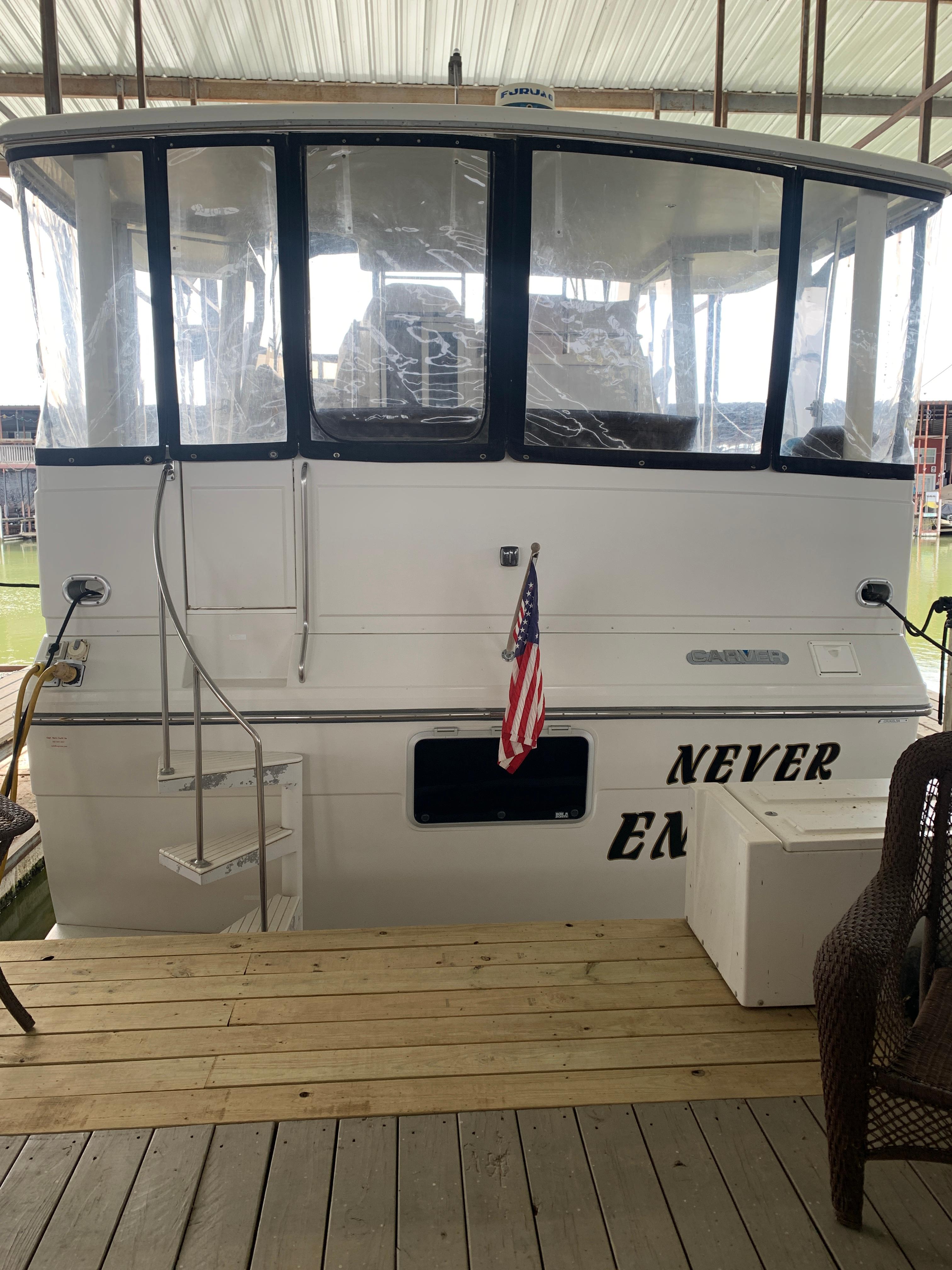 1994 Carver 440 Aft Cabin Motor Yacht docked with American flag displayed.