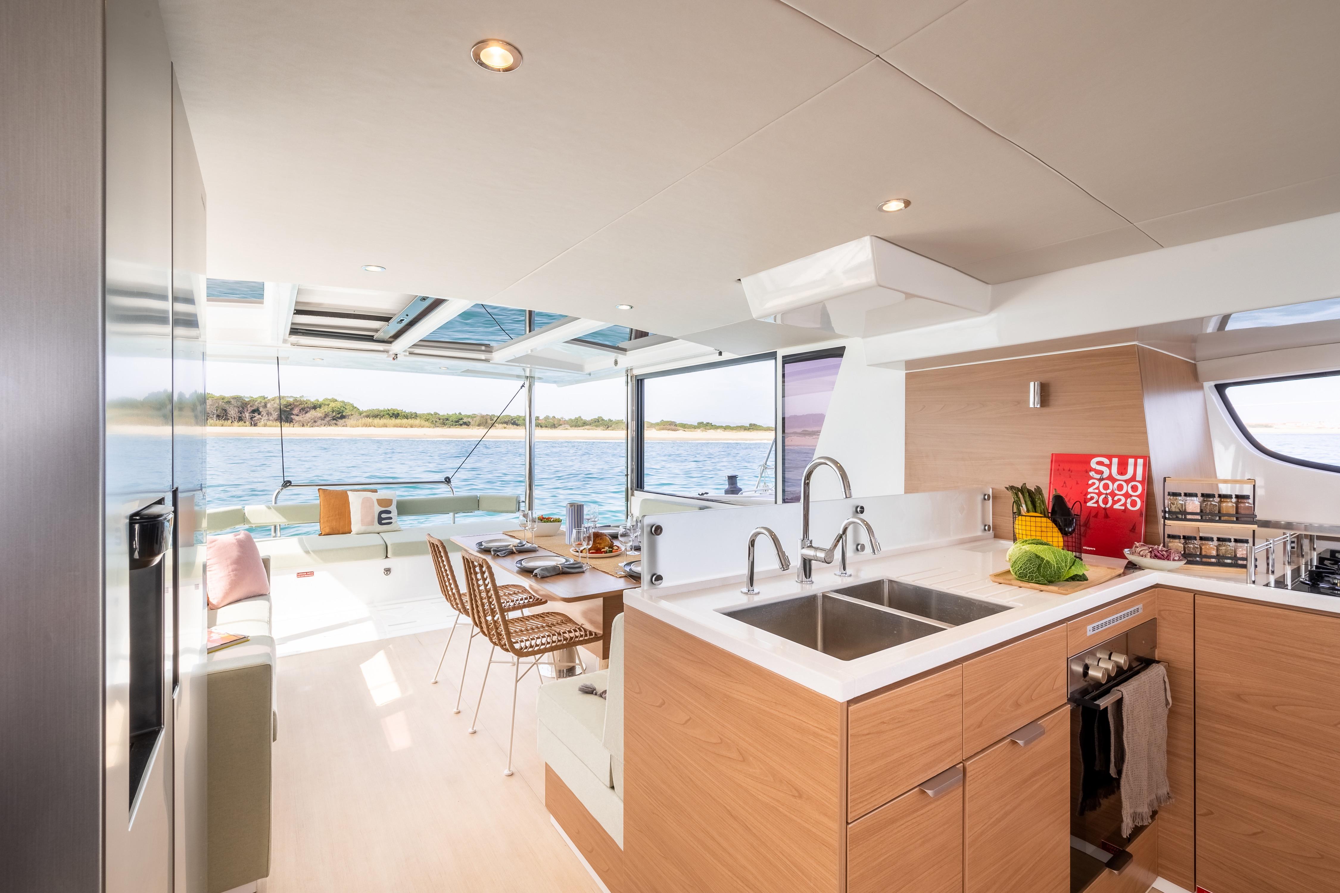 Modern Bali 4.6 catamaran interior with kitchen and dining area, overlooking serene waters, 2026 model.