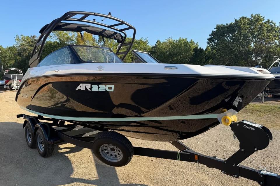 2026 Yamaha Boats AR220 on trailer, sleek black design, parked outdoors.