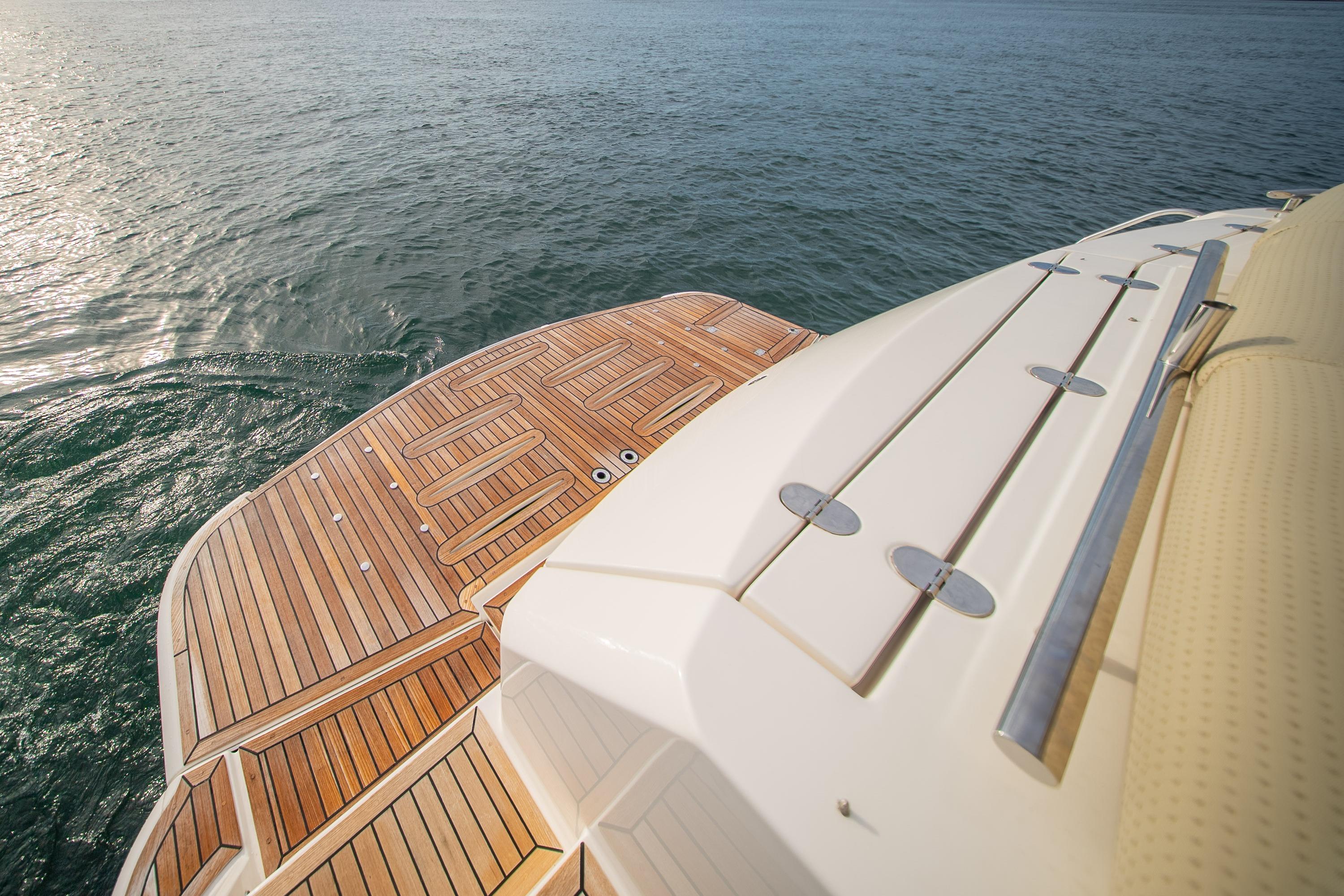 2011 Riviera 5000 Sport Yacht with teak deck, overlooking calm ocean waters.