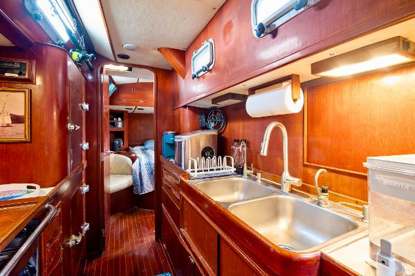 Interior of 1989 Concordia 52 yacht with wooden cabinetry and modern kitchen amenities.